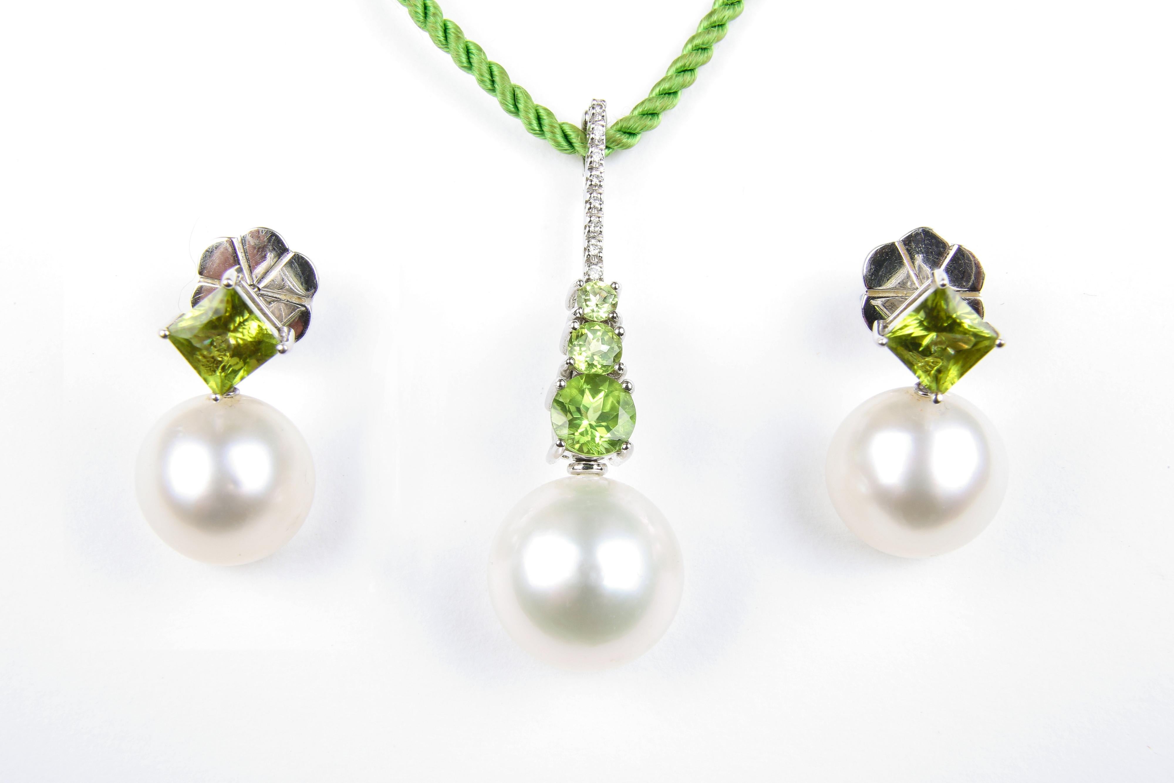 A fresh and sophisicated set of cultured South Sea pearl, peridot and diamond jewellery, comprising a pendant and matching earrings. The pendant is designed as a cultured pearl, measuring 14.1mm, suspended from a circular-shape peridot line and