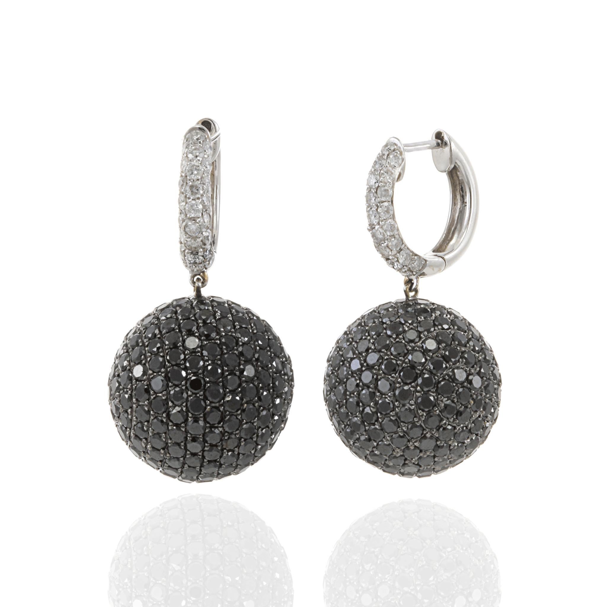 Ces boucles d'oreilles en or blanc 18 carats sont des pièces audacieuses et modernes. Elles sont composées de gouttes sphériques entièrement incrustées de 10,69 carats de diamants noirs et blancs. Les diamants noirs sertis en pavé créent une surface