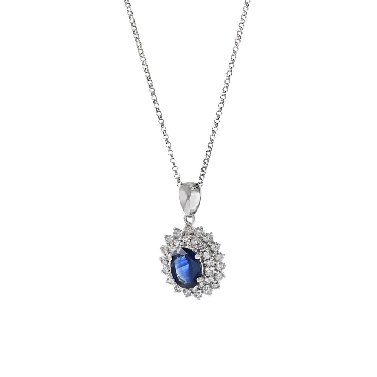 This 18KT white gold pendant necklace is a stunning piece of jewelry, featuring a genuine oval-cut blue sapphire with a weight of 1.57 carats at its center. The sapphire is elegantly surrounded by a double halo of round-cut diamonds with a combined