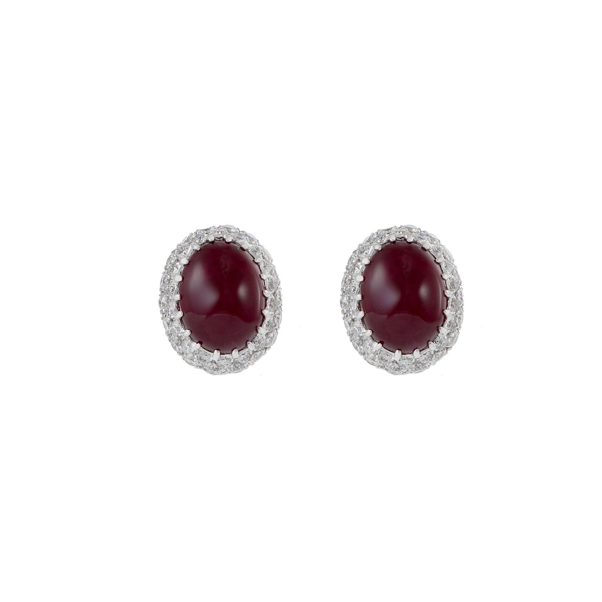These exquisite earrings are crafted in 18KT white gold, showcasing the timeless allure of two cabochon Burmese rubies with a total weight of 5.34 carats. The captivating rubies are elegantly surrounded by 0.90 carats total weight of round