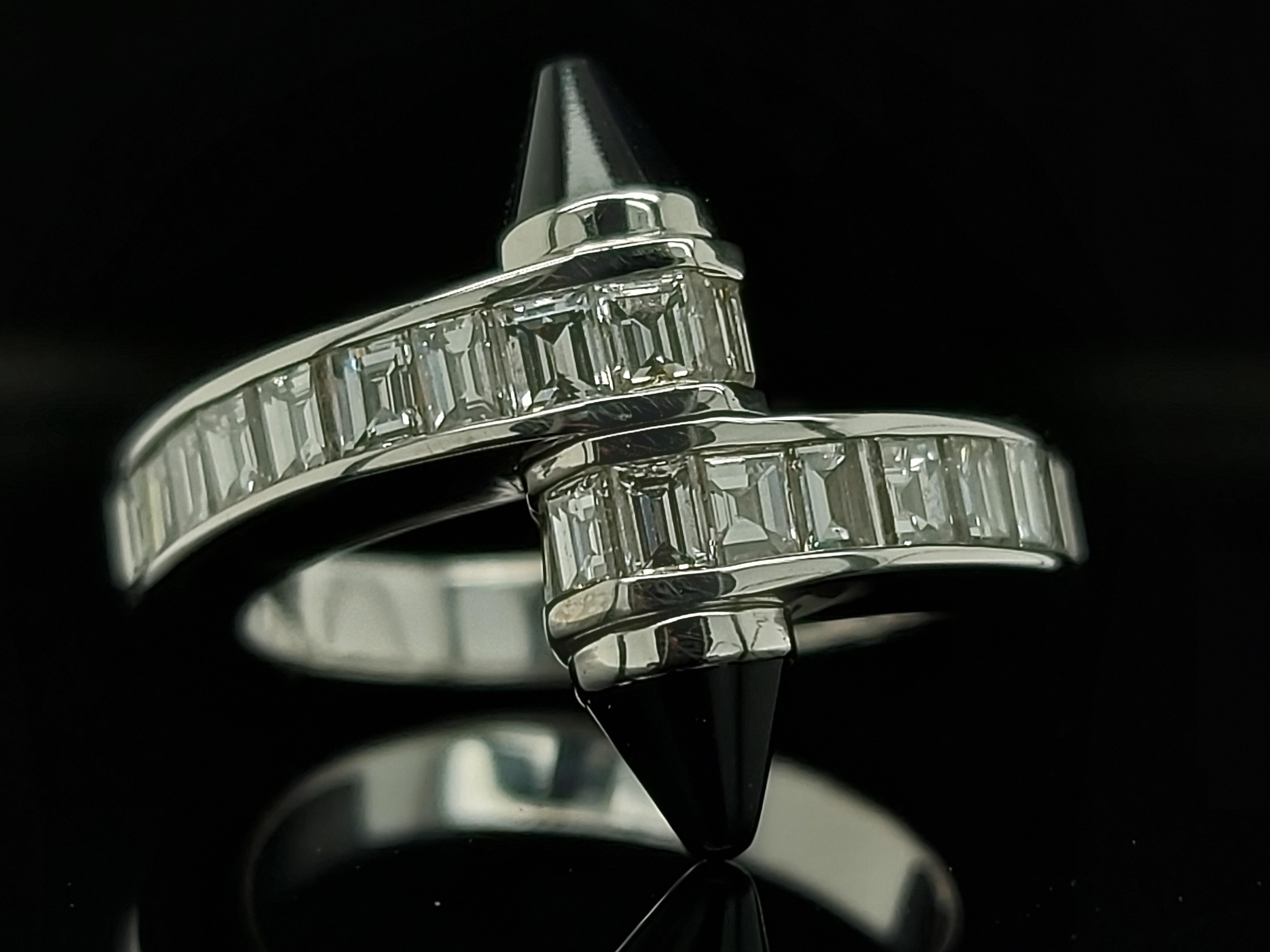 Rare and elegant 18kt white gold Cartier Menotte Baguette Diamond and Onyx Ring.

Bypass diamond ring from the Cartier Menotte Collection. 
Signed and numbered Cartier 750. Designed as a screw motif set with diamonds accented by cabochon onyx