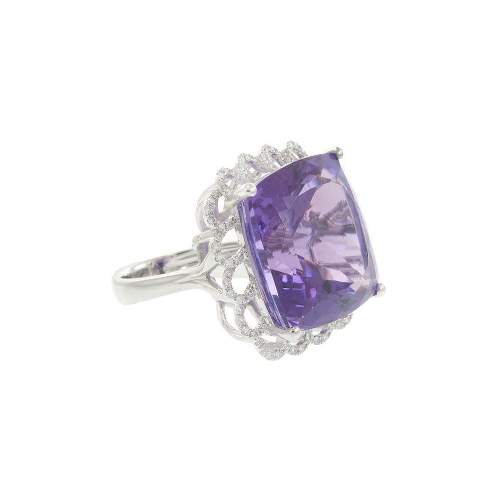 Audacieuse mais gracieuse, cette bague en or blanc 18 carats est centrée sur une améthyste époustouflante de 38,45 carats taillée en coussin, qui irradie de riches teintes violettes à chacun de ses mouvements. Un halo de diamants festonné dessine