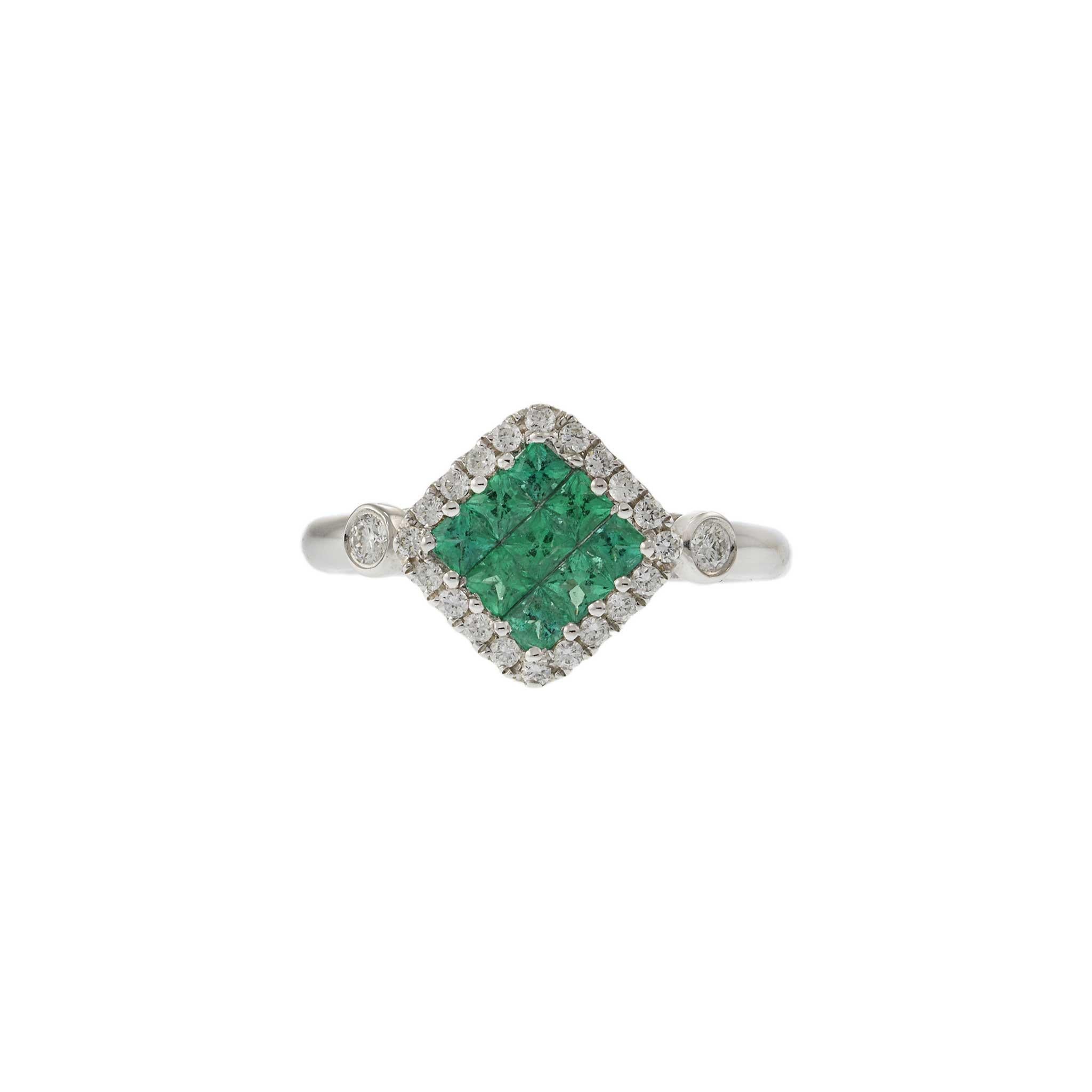 This elegant ring features 0.53 carats of princess cut emeralds, invisibly set in a cushion style halo design. Crafted in 18KT white gold, the ring is accented with 0.26 carats of round cut diamonds with G-VS clarity, adding exceptional brilliance