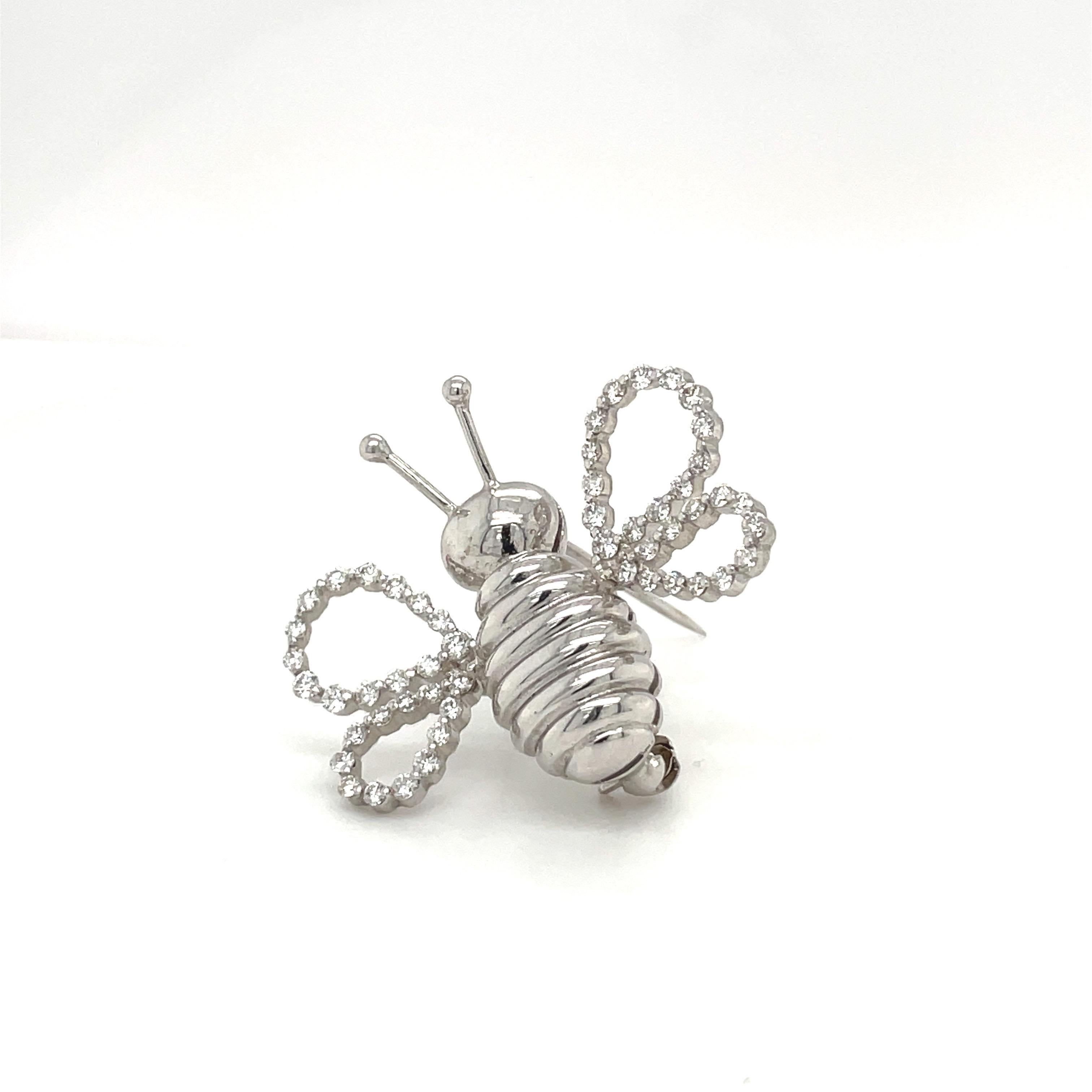 A lovely designed 18 karat white gold bee brooch. The bee is crafted in a high polished white gold. The wings are set with round brilliant diamonds. The setting is a 2 prong setting ,giving a seamless look. The bee measures 1-3/16