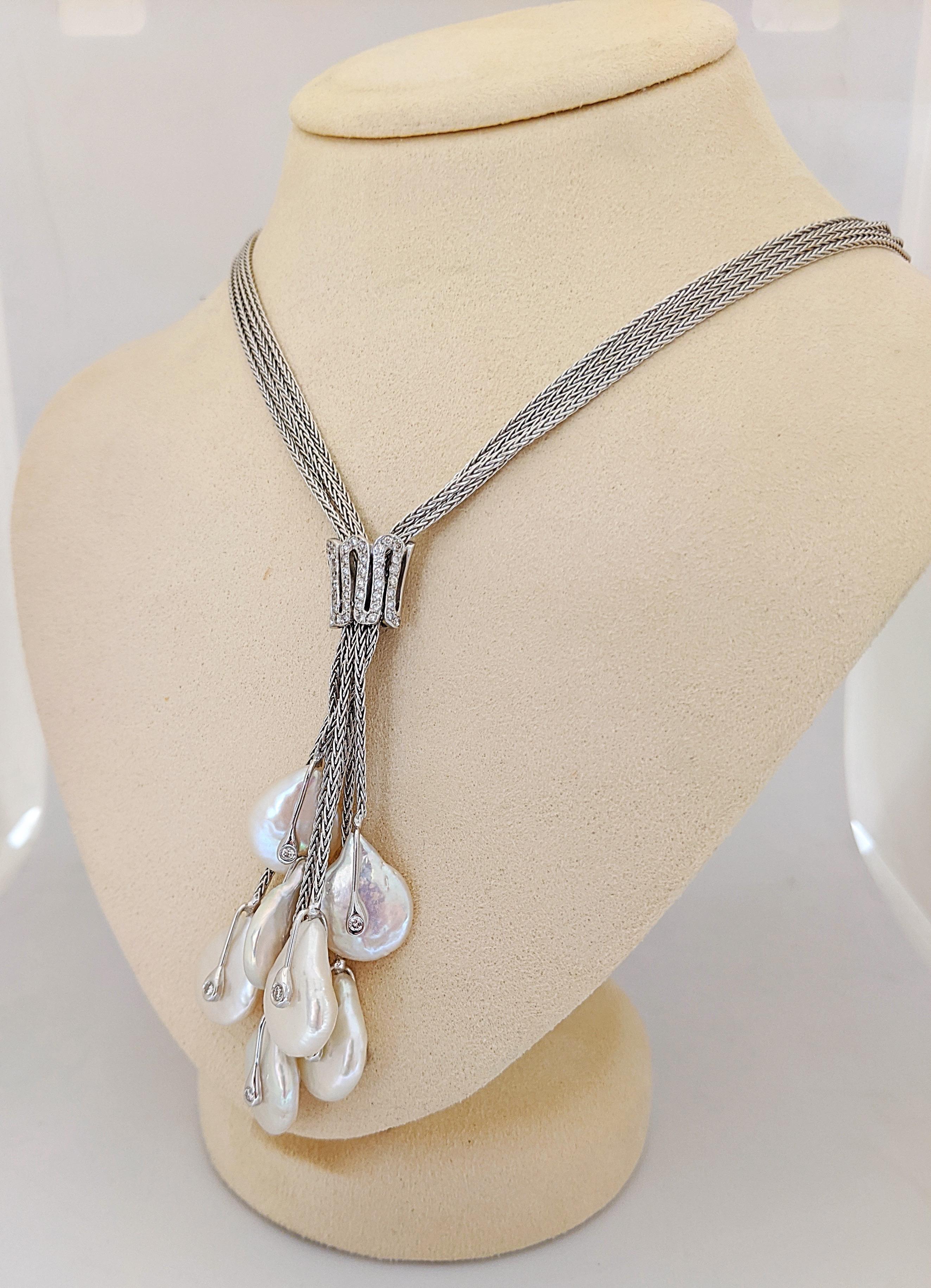 18 karat white gold necklace with seven hanging Freshwater Pearls. Each Pearl is accented with a bezel set Diamond. The Pearls hang from a four strand necklace held with a Diamond enhancer. The necklace measures 23