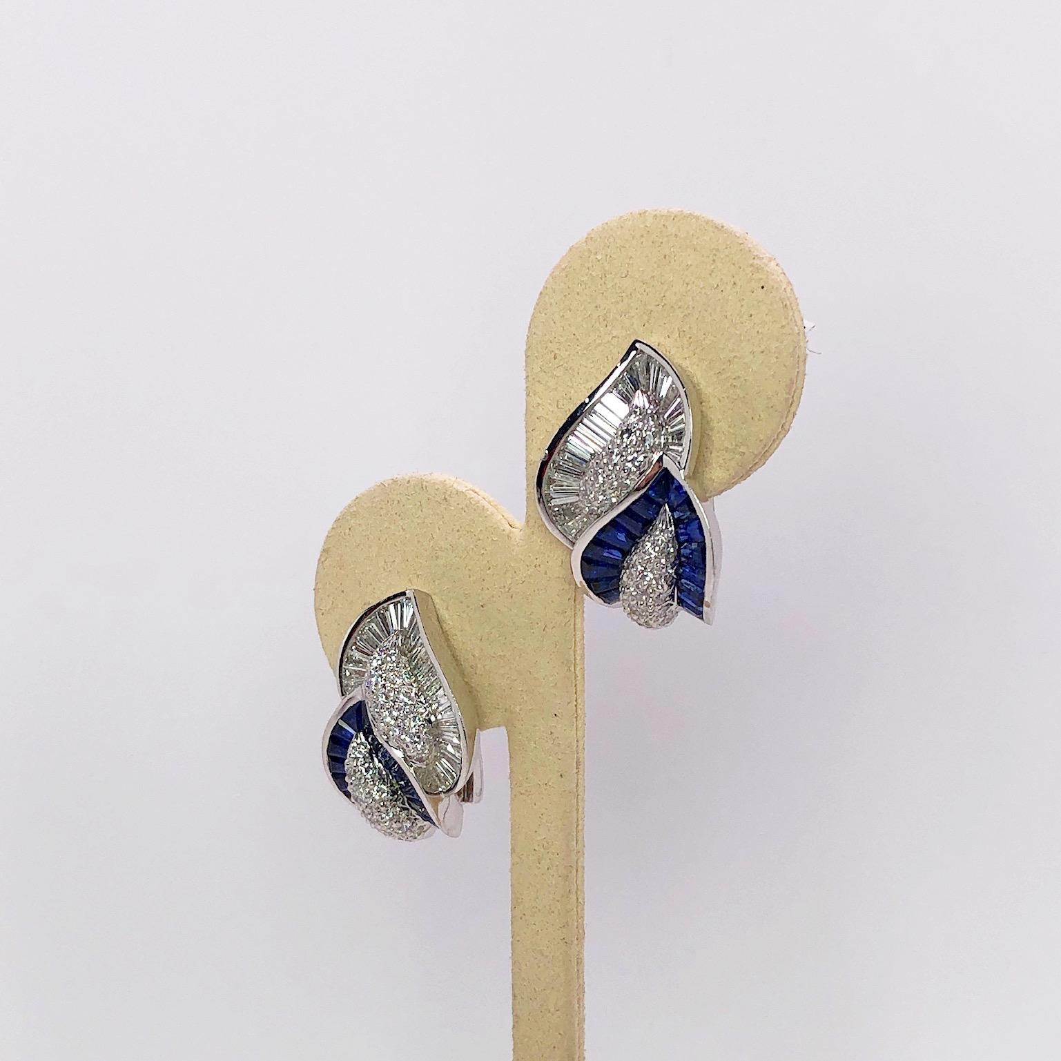 18 karat double leaf earrings .Each leaf centers a pave Diamond section. One leaf  is bordered with Diamond Baguettes, the other with Blue Sapphire Baguettes. The earrings have a collapsible post making them suitable for pierced and non pierced