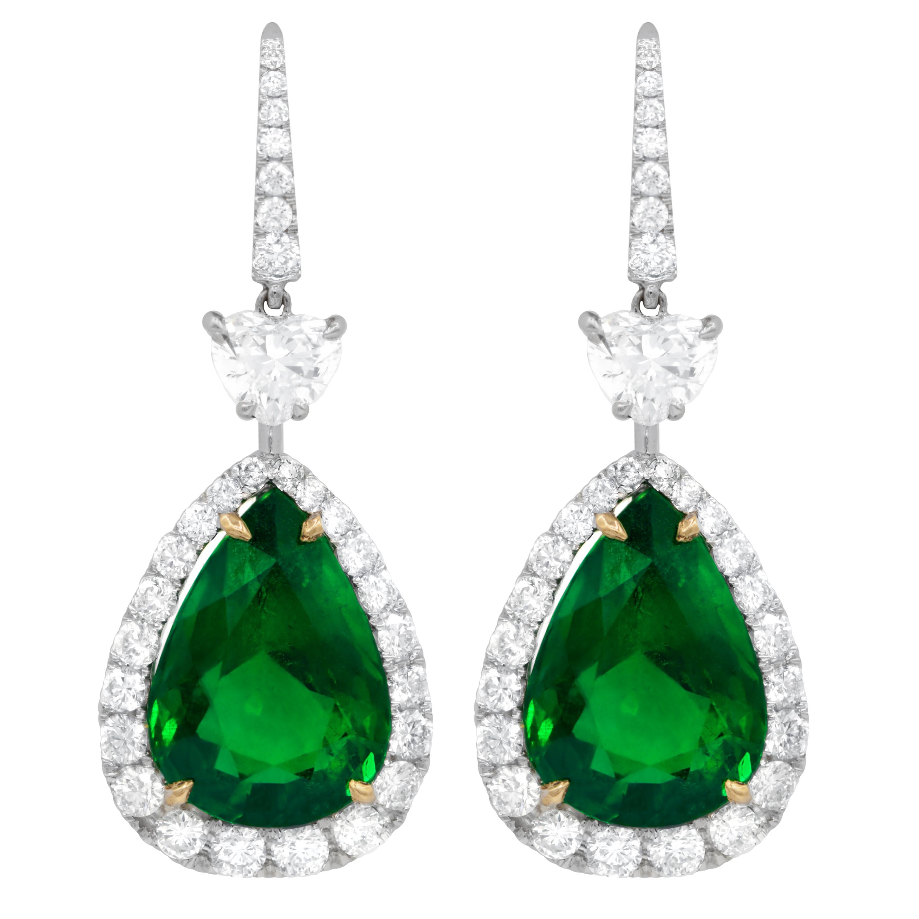 18kt white gold pear shape emerald earrings features: 15.34ct emeralds, in a halo  with 2 gia certified hearts e vs2  with total of 3.76ct of white diamonds.
