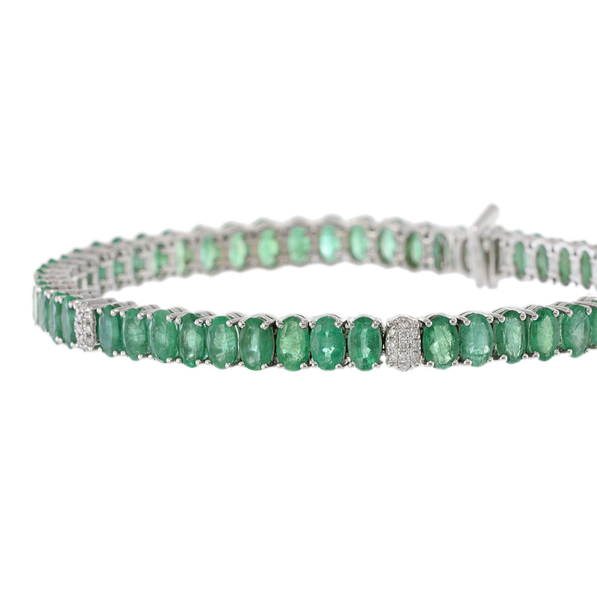 This exquisite tennis bracelet is composed of a continuous line of oval-cut emeralds, totaling 12.55 carats, each stone radiates a vibrant green hue.

Accented with round-cut white diamonds, weighing 0.09 carats, adding a touch of
