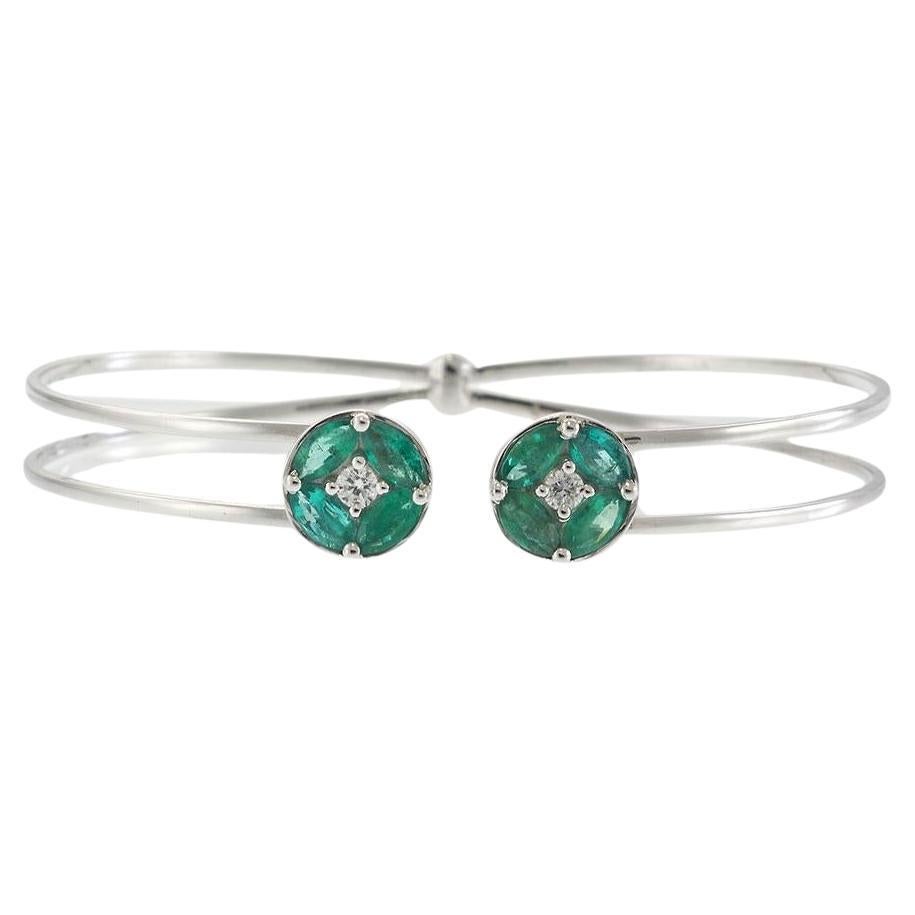 Brazalete abierto de oro blanco de 18 quilates con esmeralda y diamantes y detalles circulares en racimo