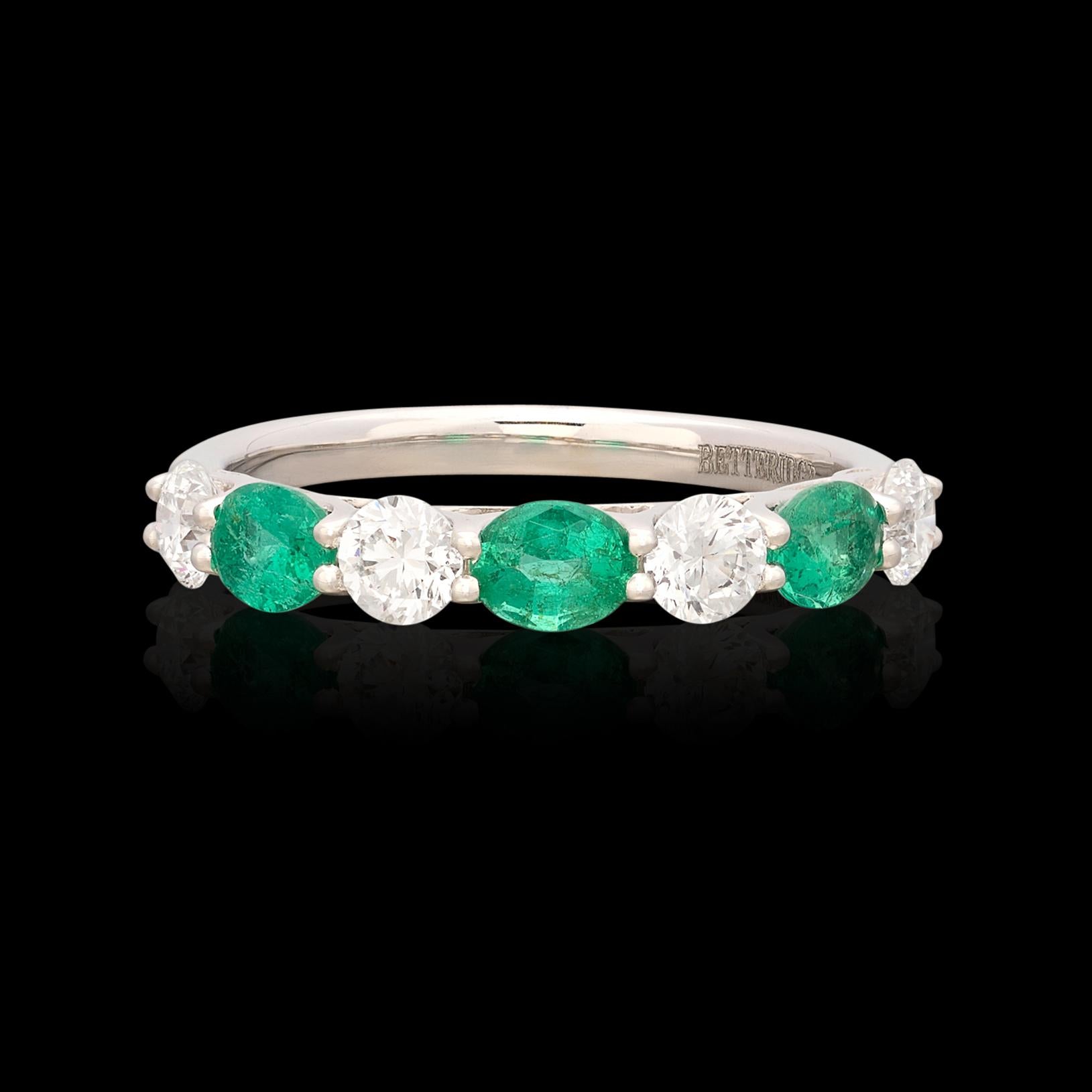 The perfect alternative wedding band or addition to any and every ring stack! This 18 karat white gold band ring features 4 incredibly well match natural diamonds alternating with 3 vibrant green emeralds. The diamonds come together for 0.75 carats