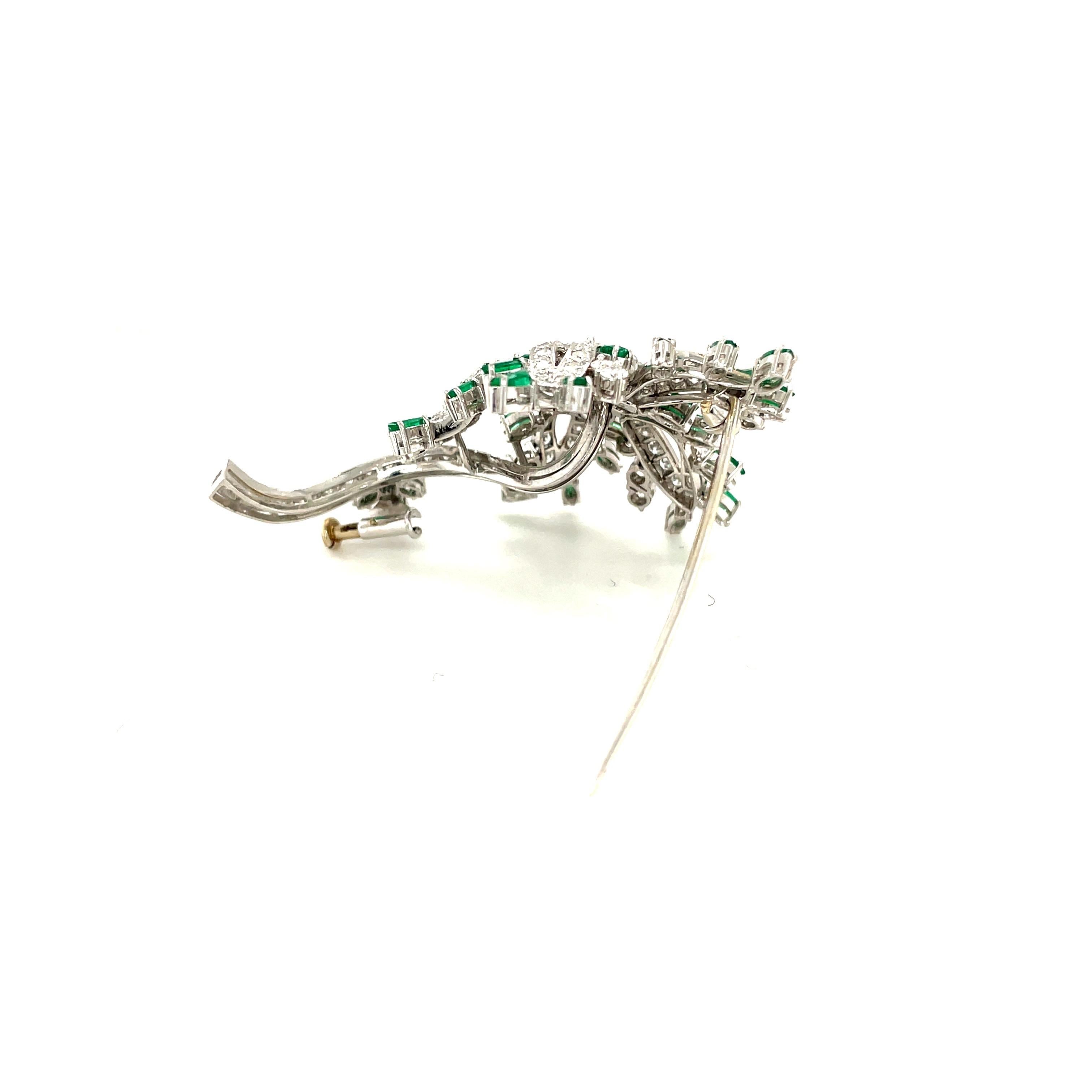 Beautiful 18 karat white gold classic brooch. This flower brooch is magnificently set with 6 round brilliant diamonds in it's center, and 98 round brilliant diamonds are set as the leaves and stem. The flower is tipped with 25 marquise cut emeralds.