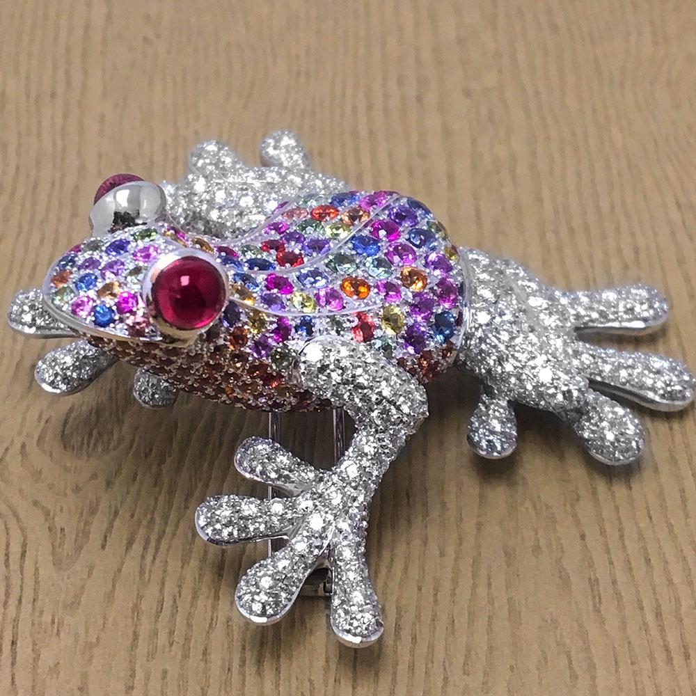 A frog is a good luck symbol in many cultures, also a symbol of fertility, transformation and safe travels.
This adorable frog brooch is set with a pastel palette of multi colored Sapphires . His webbed arms and feet are set with round brilliant