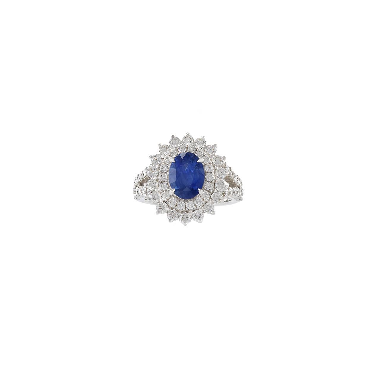 This elegant 18KT white gold ring features a GIA Certified 1.81CT Oval Cut Blue Sapphire surrounded by a double halo of 1.65CT-TW round-cut G-VS diamonds, creating a captivating and sophisticated design. Perfect for special occasions or as a