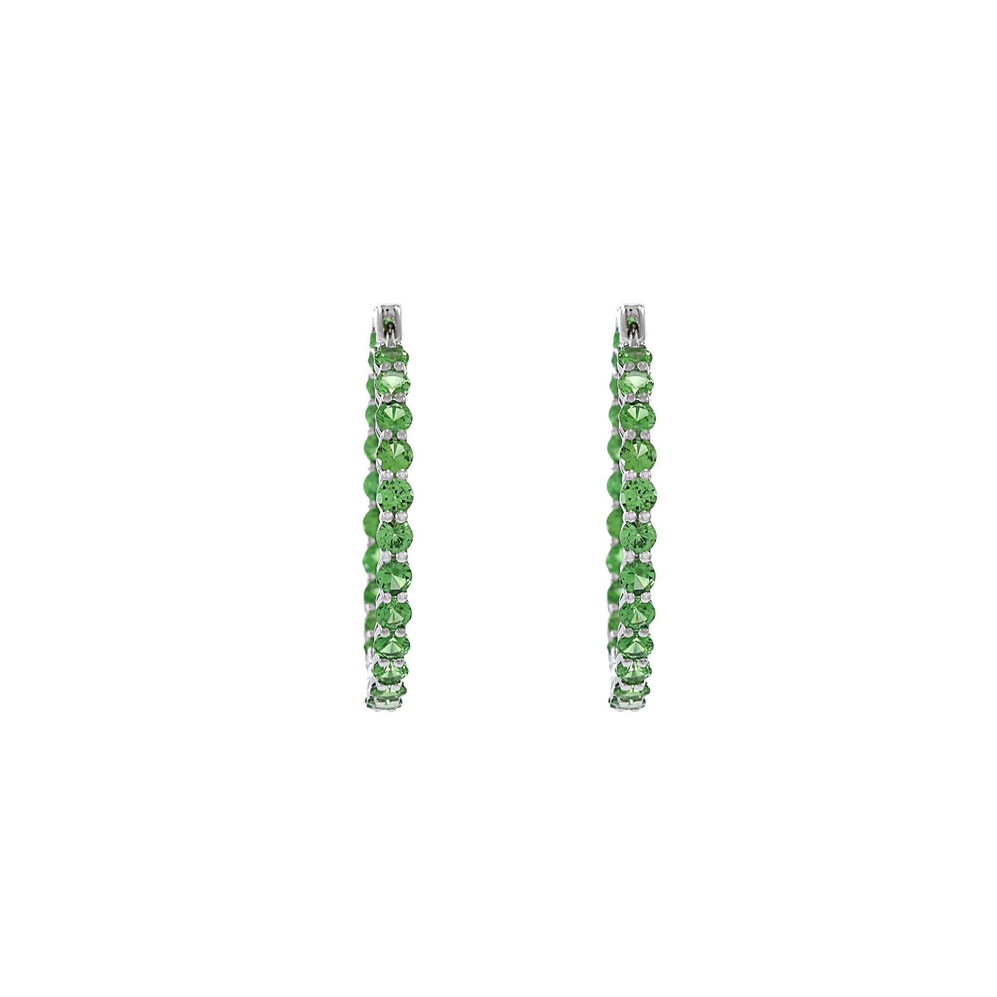 These stunning 18KT white gold in-and-out hoop earrings feature a total of 4.08 carats of round-cut green tsavorites. The vibrant green hue of the tsavorites adds a pop of color and elegance to the classic hoop design. Crafted with precision and