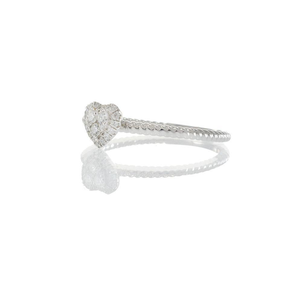 Celebra l'amore nella sua forma più elegante con questo affascinante anello con diamante a cuore in oro bianco 18KT. Il romantico centro è caratterizzato da un grappolo di diamanti a forma di cuore, incorniciato da un'aureola scintillante per una