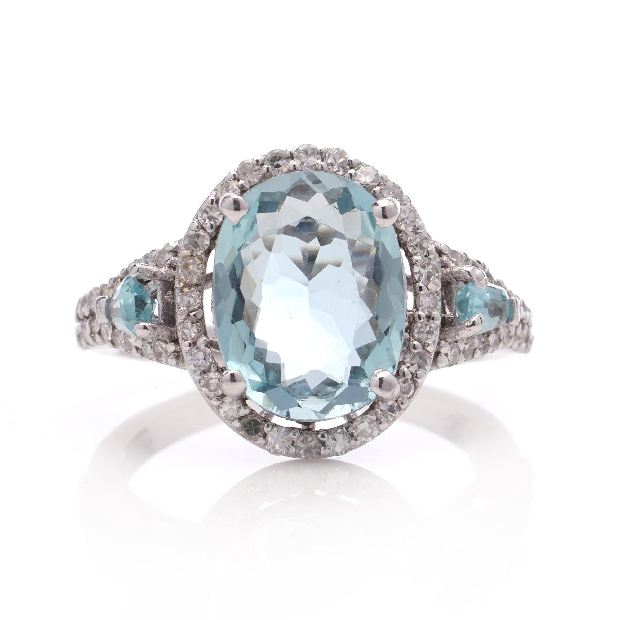 18kt. white gold ladies' 2.90 carats Aquamarine cluster ring surrounded by 0.56 carats of round brilliant diamonds and accented with two 0.24 carats of tapered baguette-cut aquamarines. 
Made after 2000

Hallmarked with 750 ( 18KT. GOLD )