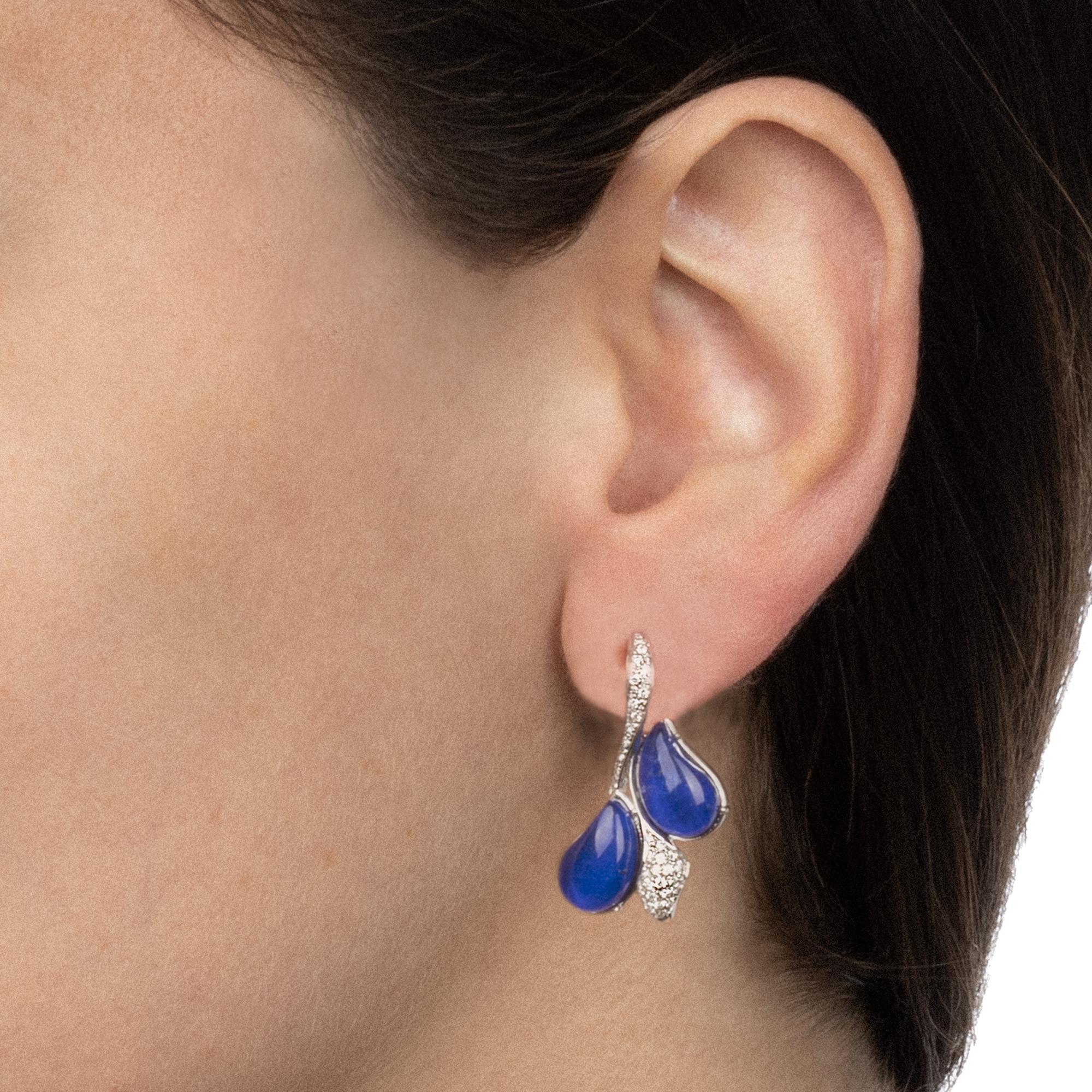 Fresh and playful like a summer memory, these earrings are classy and efferverscent at the same time. The pendants have the shape of a cluster of drop-shaped elements, alternating the deep blue lapis lazuli gemstones and sparkling diamonds. Designed