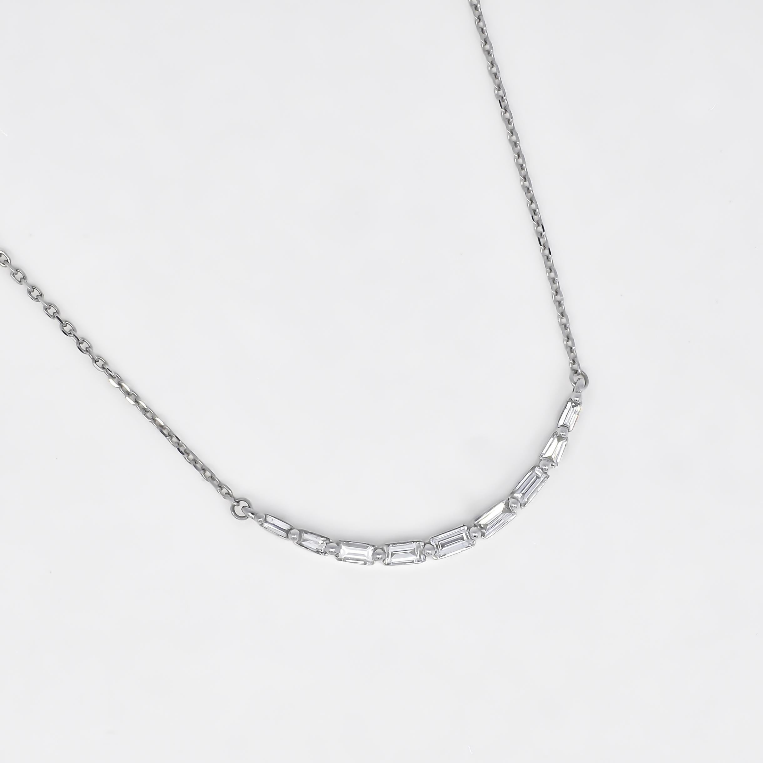 Lasciati conquistare dall'eleganza senza tempo di questa collana pendente mozzafiato, caratterizzata da un'unica linea di diamanti baguette incastonati orizzontalmente che creano un sorprendente design a barra curva. 

Incastonato in un lussuoso oro