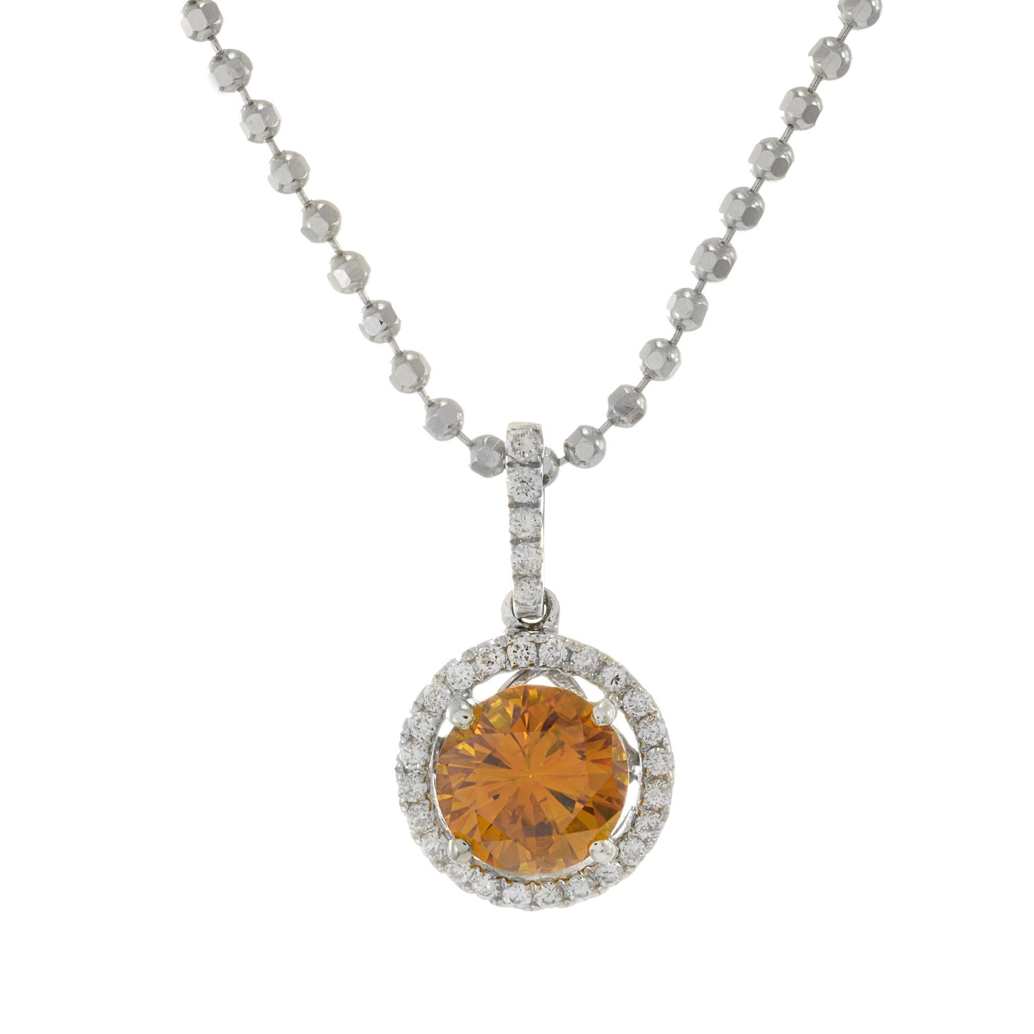 Adorn yourself in the brilliance of this 18KT white gold halo diamond necklace, featuring a centerpiece of a GIA certified 1.03ct natural deep fancy yellow-orange round-cut diamond. The vibrant gem is encircled by a halo of G-VS round-cut diamonds,
