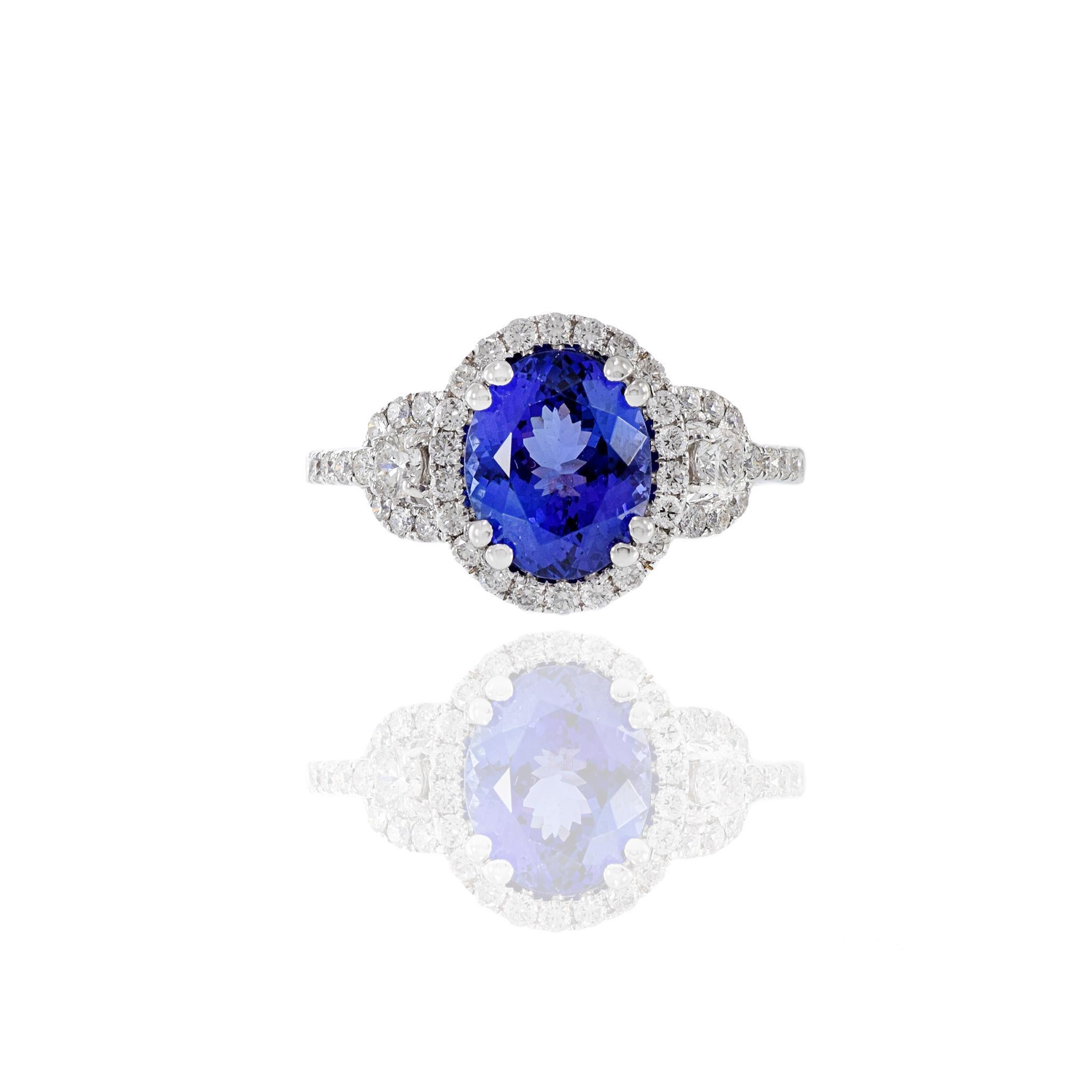 This 18KT white gold ring is a symbol of elegance and sophistication, featuring a central 2.60CT oval-cut tanzanite surrounded by a halo of 0.68CT-TW G-H color, VS1-VS2 clarity round-cut diamonds. This piece is a captivating addition to your