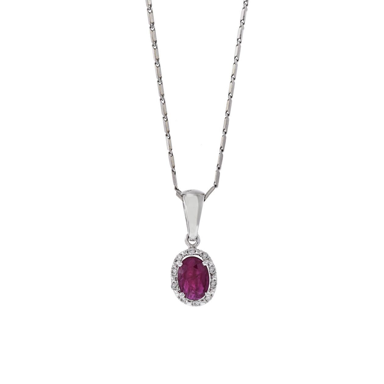 Este colgante de oro blanco de 18 quilates presenta un cautivador Rubí de forma ovalada de 0,63 quilates, rodeado por un brillante halo de diamantes de talla redonda que suman 0,05 quilates. La combinación del vibrante Rubí y los brillantes