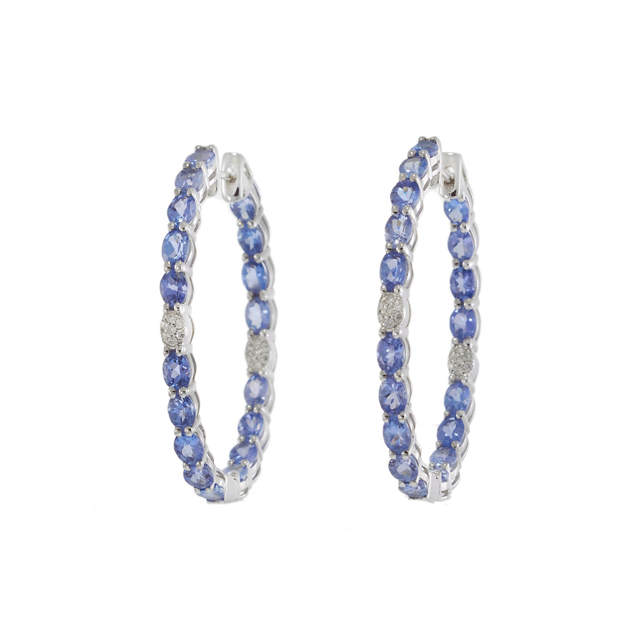 Cette paire d'Eleg en or blanc 18KT, conçue dans un style élégant, met en valeur des tanzanites de taille ovale de 6.58CT-TW qui rayonnent d'une riche teinte bleue-violette. Des diamants de taille ronde de 0,14CT-TW rehaussent le design et ajoutent