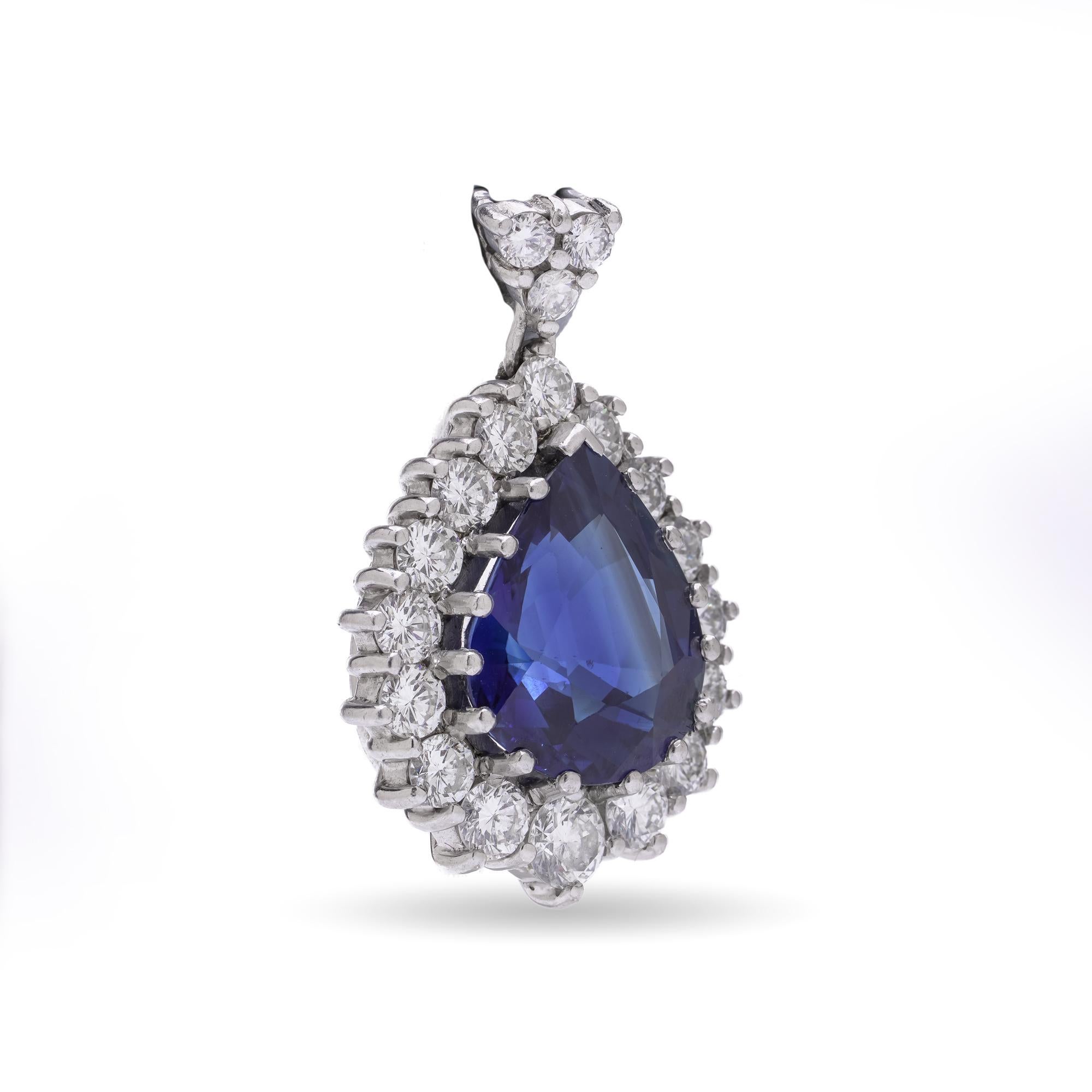 A stunning 18kt white gold pendant featuring a natural Ceylon pear-shape sapphire weighing approximately 5.00 carats, surrounded by 19 round brilliant-cut diamonds totalling ~1.00 carat, of VS1 clarity and F colour. The sapphire exhibits exceptional