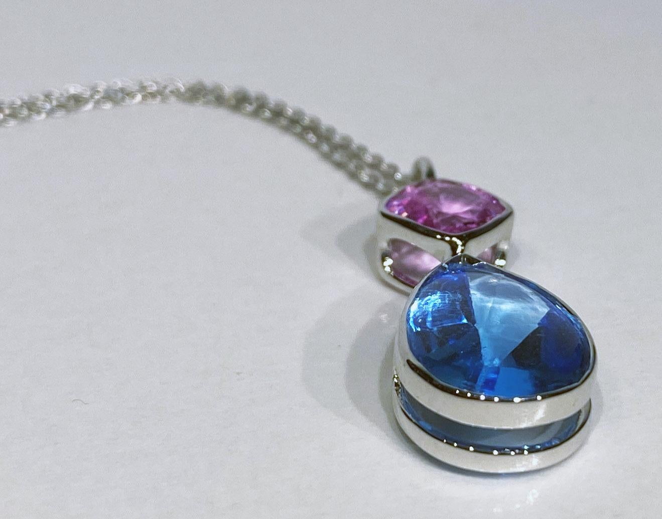 An 18kt White Gold Pendant set with Blue Topaz & Pink Sapphire. 18kt White Gold weight is 4.7 Grams. Blue Topaz is a Cabochon Dome Top with a Faceted Pavillion in a Pear Cut. Topaz  weight is 3.885 Carats, Pink Sapphire Cushion cut weight is 1.98