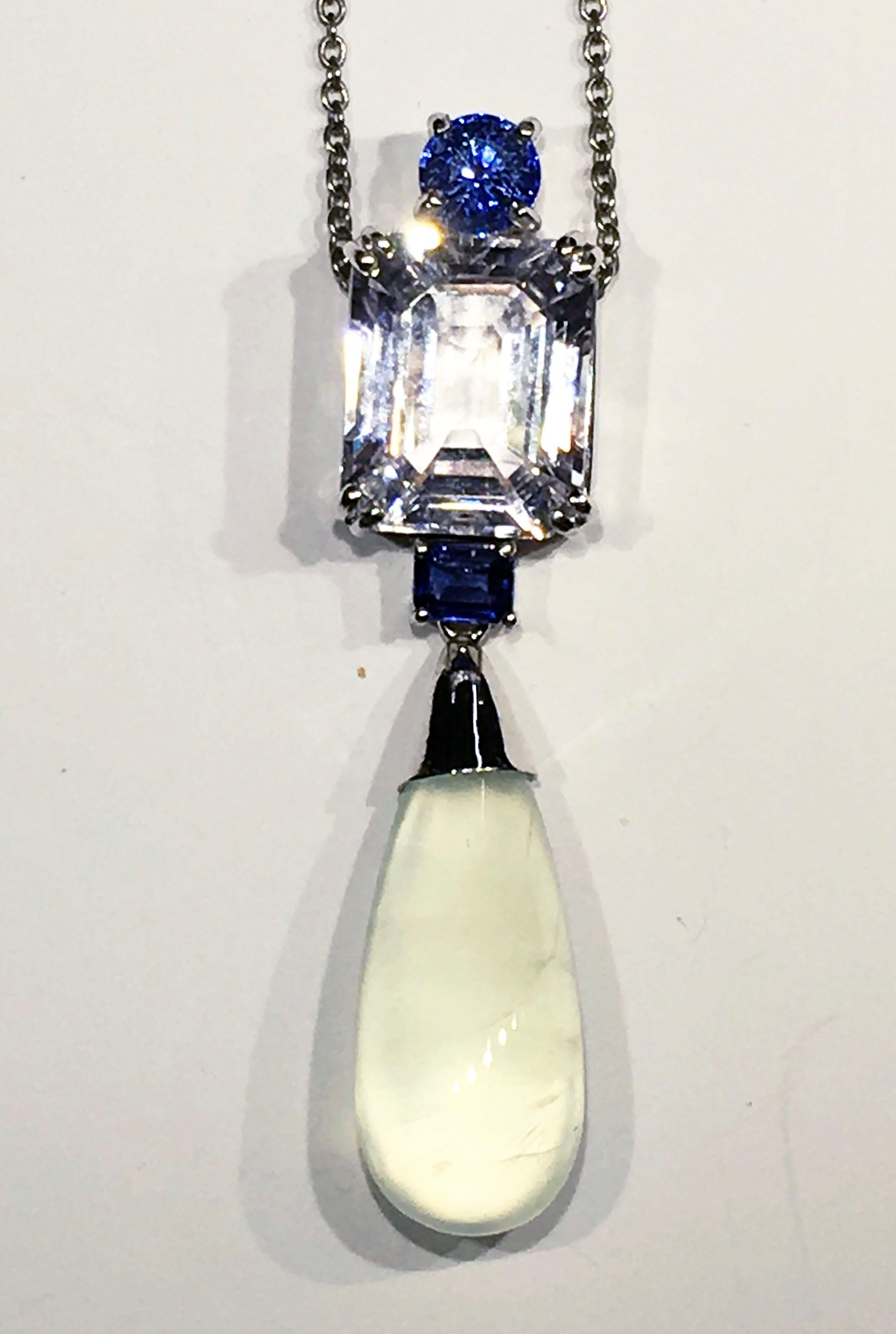 Kary Adam Designed, 18kt White Gold Pendant Set with One Small Round Blue Sapphire and a Second Emerald Cut Blue Sapphire Totaling 0.47 Carats. Also Set with an Emerald cut Morganite of 6.7 Carats & a 9.2 Carat Prehnite Drop Cabochon. This is