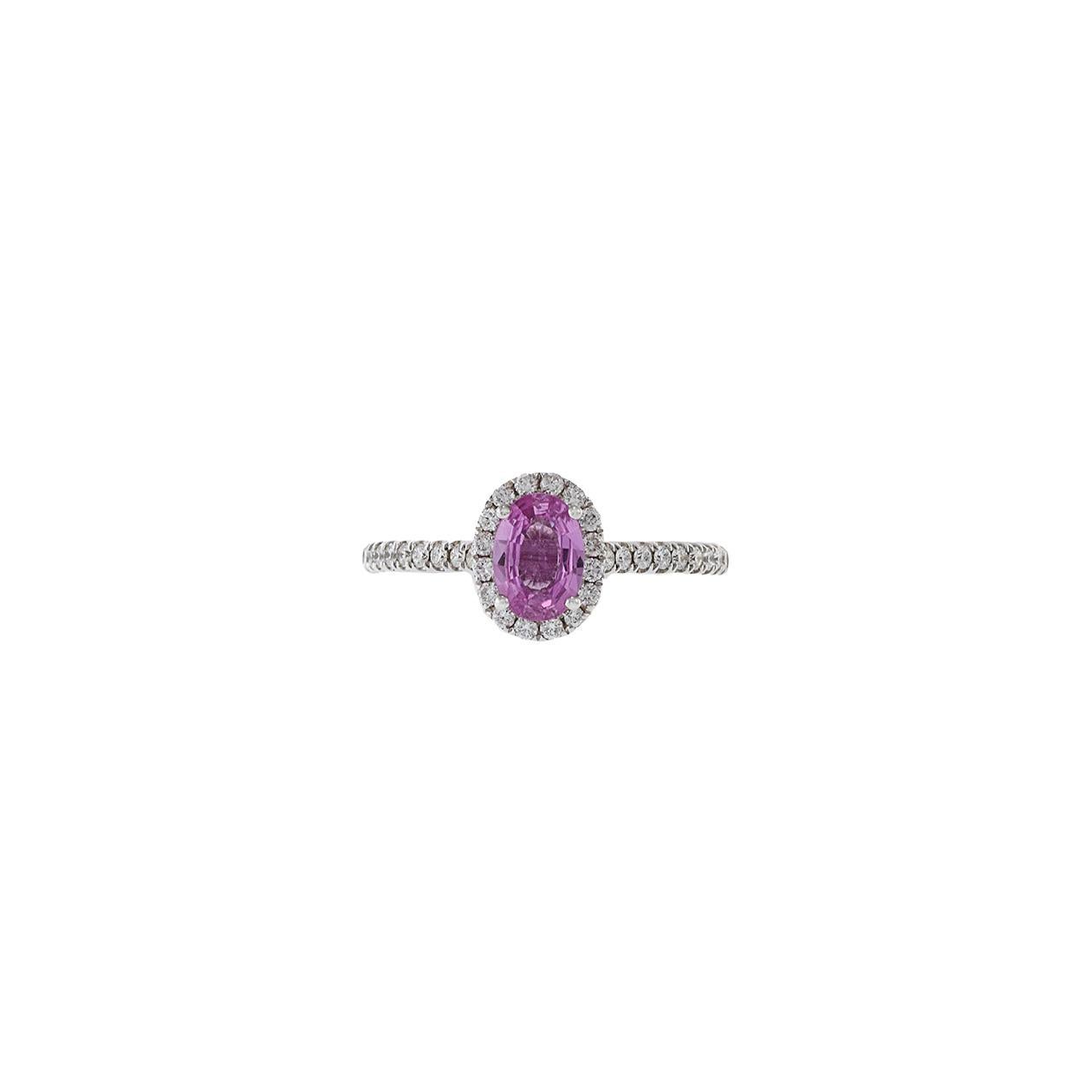 Anello con zaffiro rosa e diamanti in oro bianco 18 carati, con uno zaffiro rosa di taglio ovale da 1,02 carati circondato da diamanti a taglio rotondo di peso totale pari a G, di purezza VS1-VS2. Taglia 6 US. Peso 3,1 gm.