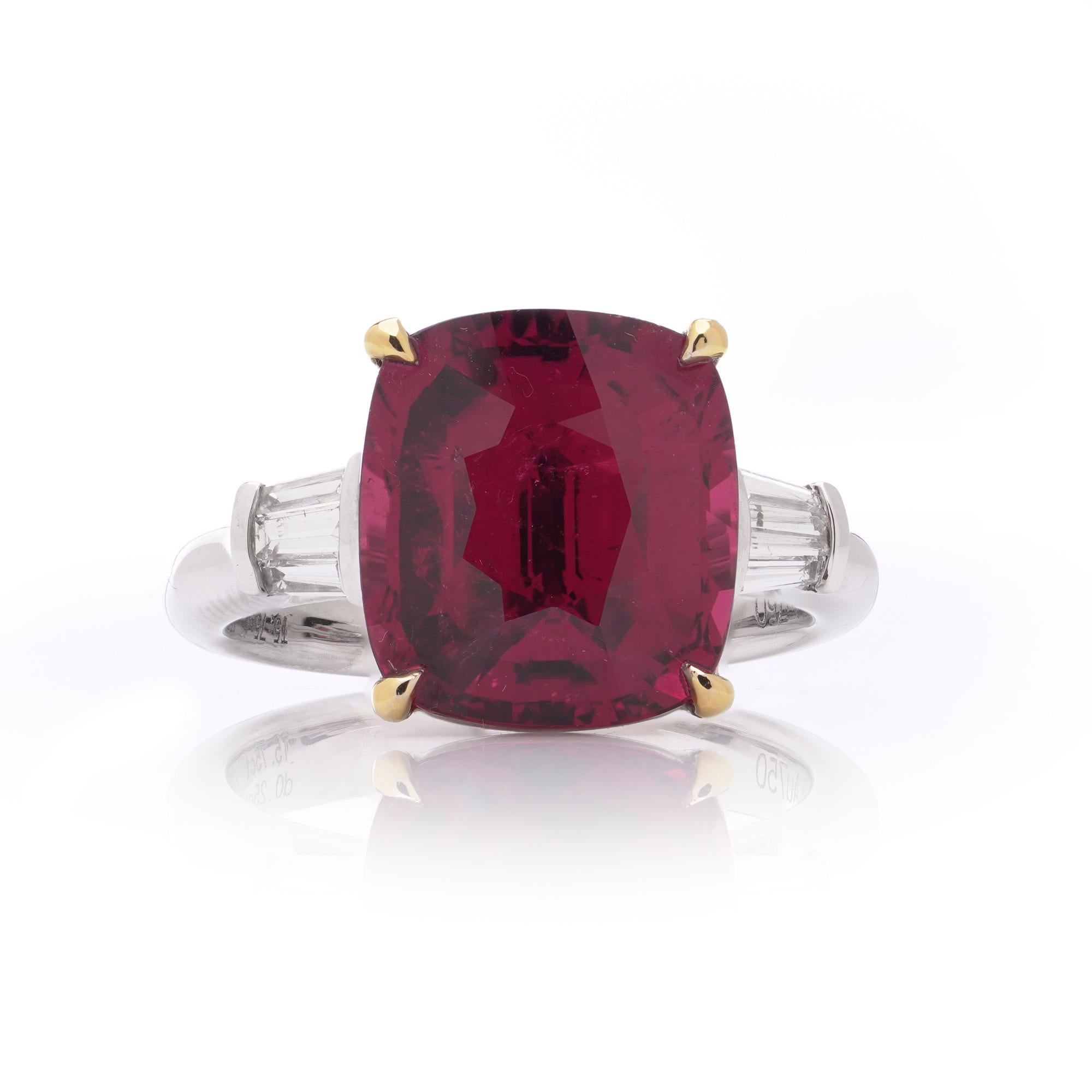 Un bellissimo anello in oro bianco 18 carati con una vibrante tormalina rosa da 5,75 carati, accentuata da due diamanti affusolati con taglio a baguette per un totale di 0,25 carati. La tormalina centrale mostra un'intensa tonalità rosa-rossa,