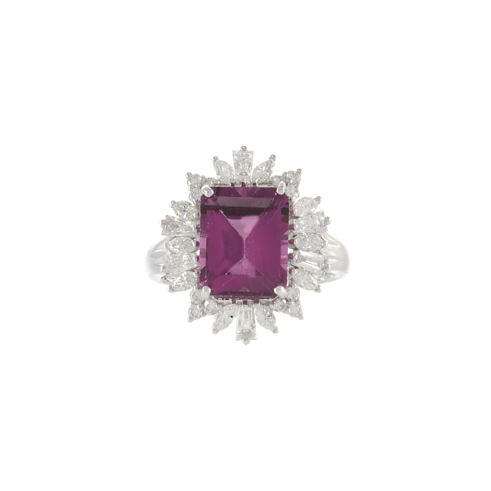 Savor the artful combination of Rhodolite garnet, diamonds, and luxurious 18KT white gold. The stunning rectangular cut pink Rhodolite stone, boasting 5.04 carats, is framed and enhanced by a surrounding of 0.95 carats of G-VS/SI round, marquise,