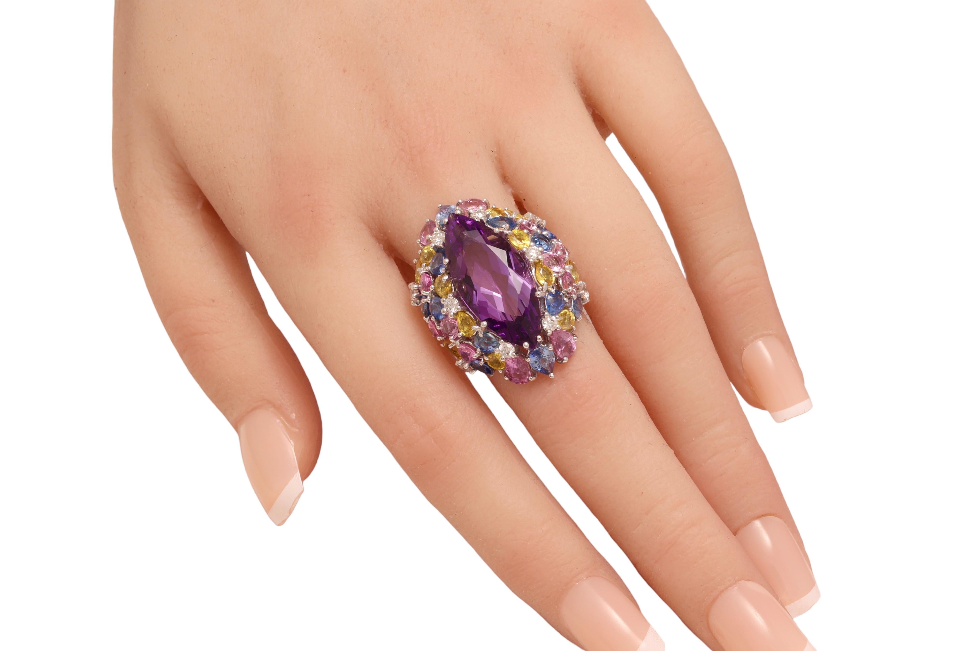 Magnificent 18kt White Gold Ring With Huge Marquise Cut Amethyst Center Stone & Blue, Pink Sapphires, Diamonds 

Centre stone: amethyst Approx. 20 Ct

Diamonds: brilliant cut together 0.58 ct.

Pink, blue and yellow sapphire Approx. 14 Ct

Material: