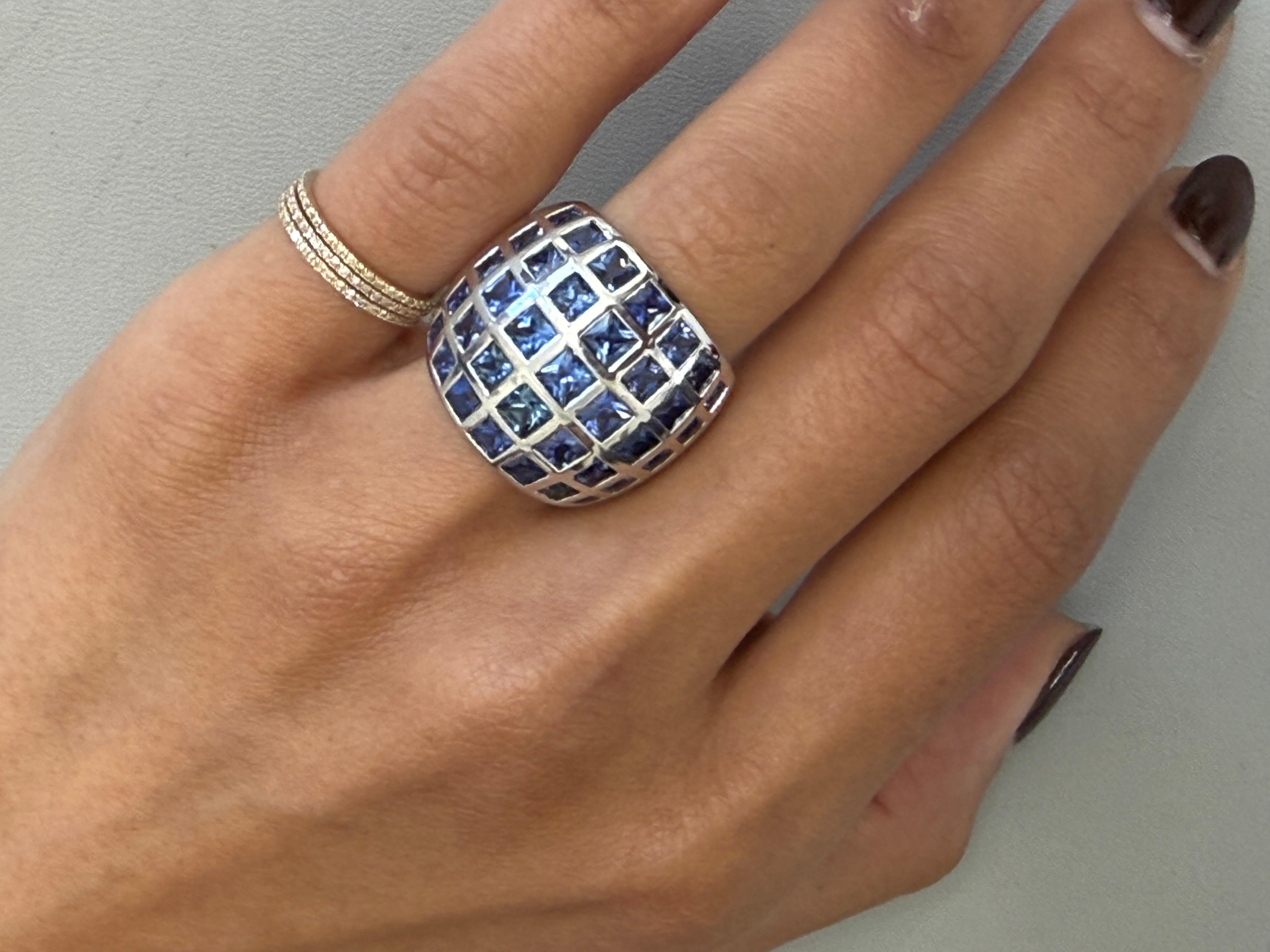 Dieser leuchtende Ring präsentiert 35 blaue Saphire im Präzisionsschliff mit einem Gesamtgewicht von 6,10 Karat, eingefasst in ein elegantes, durchgehendes Band aus 18 Karat Weißgold. Die scharfen Facetten jedes einzelnen Saphirs im Quadratschliff