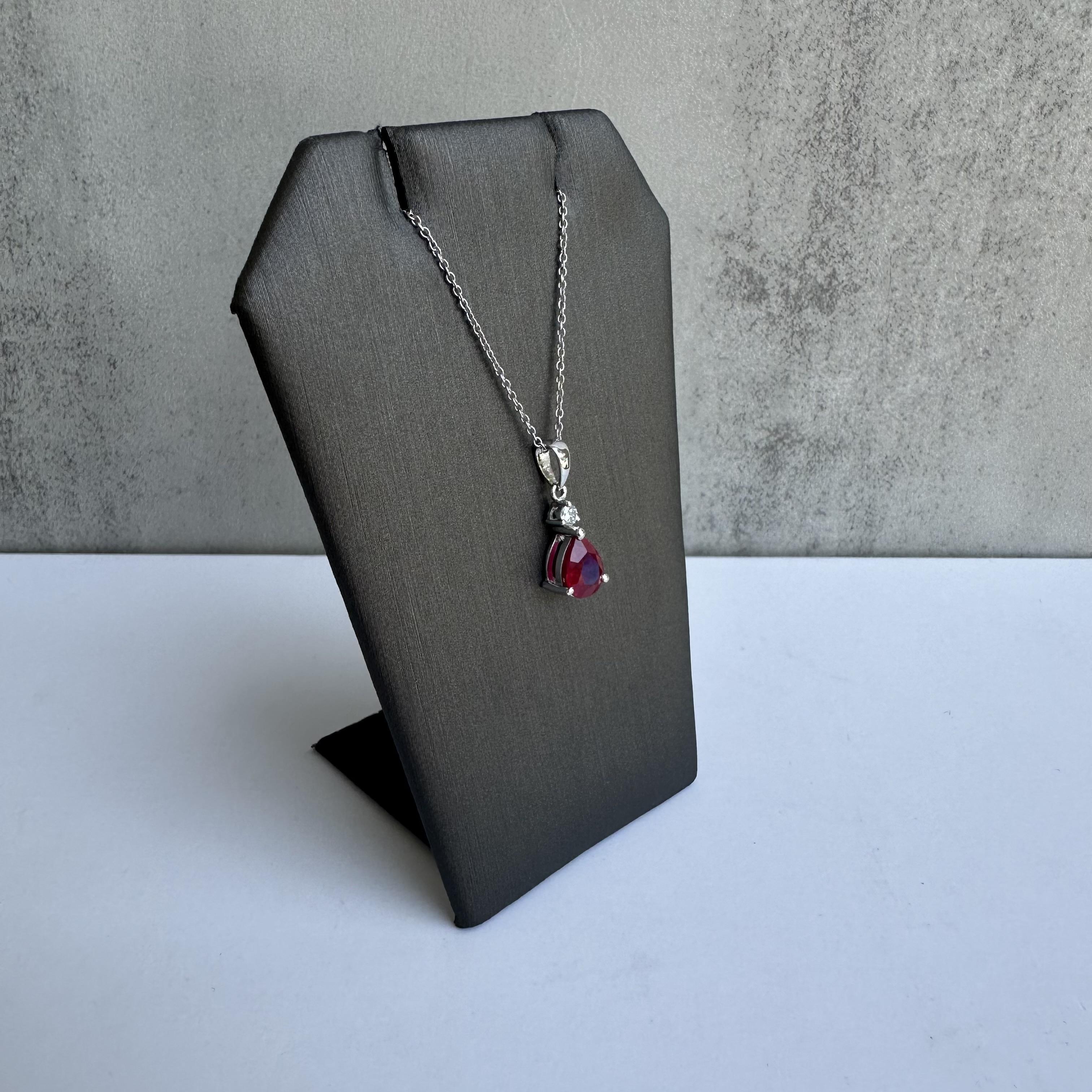 Offrez-vous le luxe avec ce superbe collier en or blanc 18 carats orné de rubis et de diamants. Doté d'un magnifique rubis naturel de 1,22 carat en forme de poire et d'un étincelant diamant rond naturel de 0,05 carat G VS1, ce collier est une