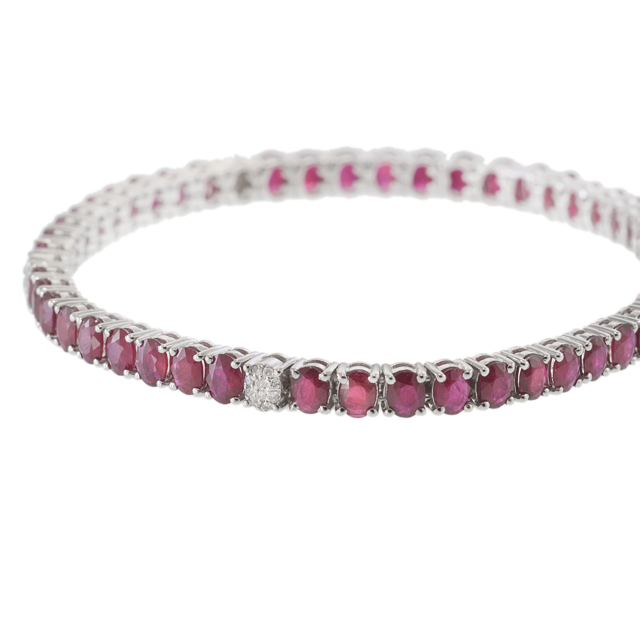 El color vivo se une al diseño atemporal en esta llamativa pulsera de tenis de oro blanco de 18 quilates. Con una elegante hilera de rubíes de talla ovalada y ricos matices que suman 9,99 quilates, esta pieza está realzada con brillantes diamantes