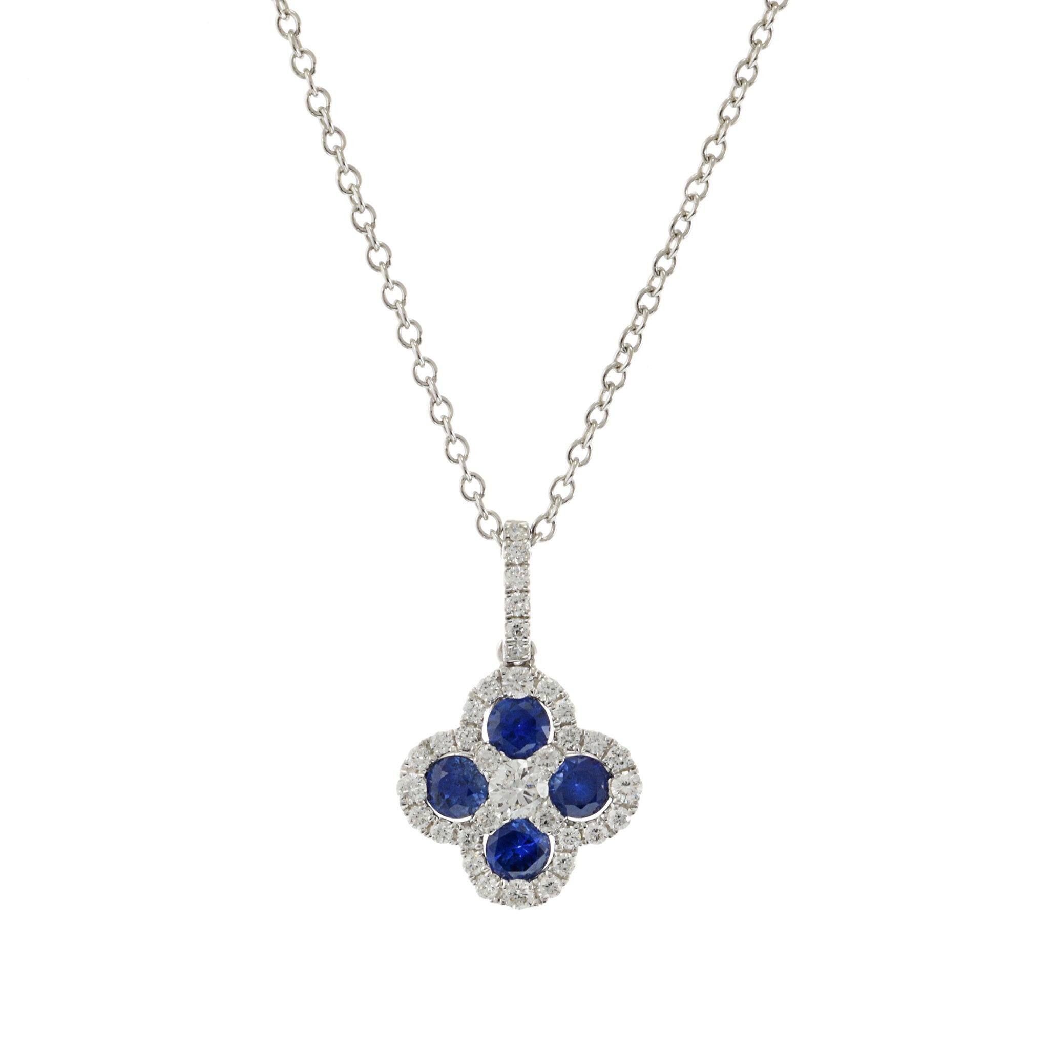 Questo raffinato ciondolo presenta un design a trifoglio, realizzato in oro bianco 18KT. È impreziosito da 0,40 carati di zaffiri blu a taglio rotondo e 0,24 carati di diamanti a taglio rotondo, che aggiungono un tocco di eleganza e scintillio.
