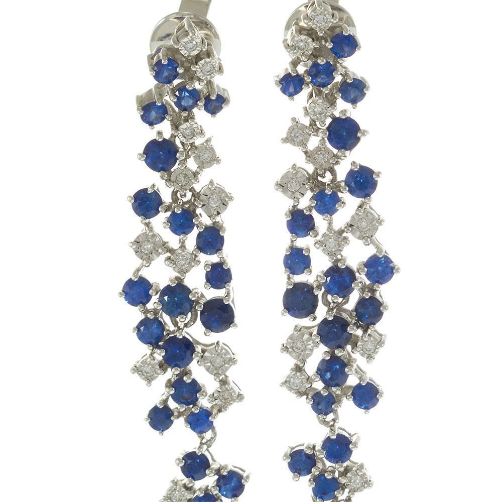 Exquises et gracieuses, ces boucles d'oreilles pendantes en or blanc 18 carats présentent une étonnante série de diamants ronds et de saphirs bleus profonds dans un design en cascade. Les diamants, totalisant 1,20 carats, apportent un éclat radieux