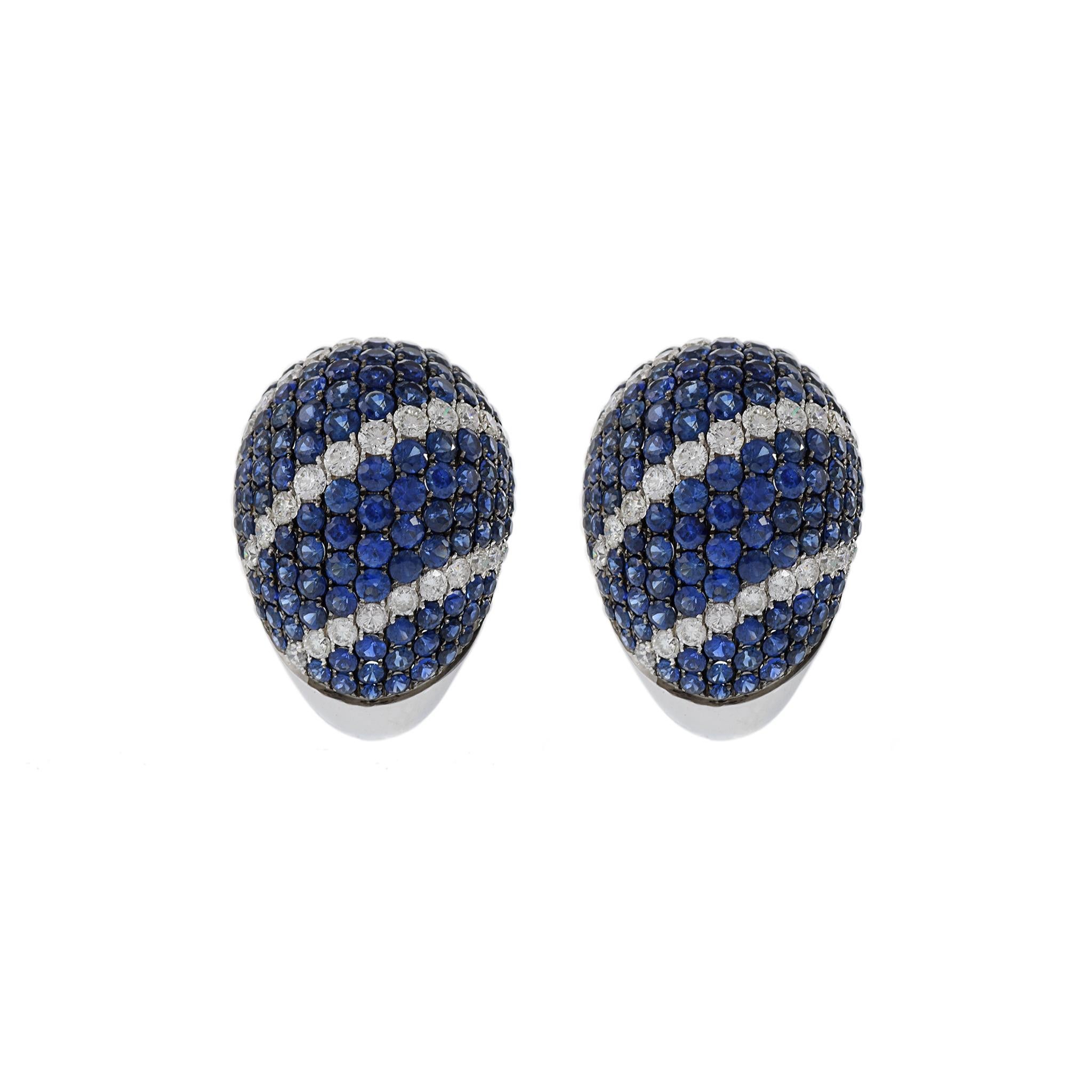 These huggie earrings are a remarkable statement of luxury, meticulously crafted from 18KT white gold and adorned with a total of 7.90CT-TW Blue Sapphires and 1.68CT-TW of round-cut diamonds, known for their exceptional F color and VS clarity. The