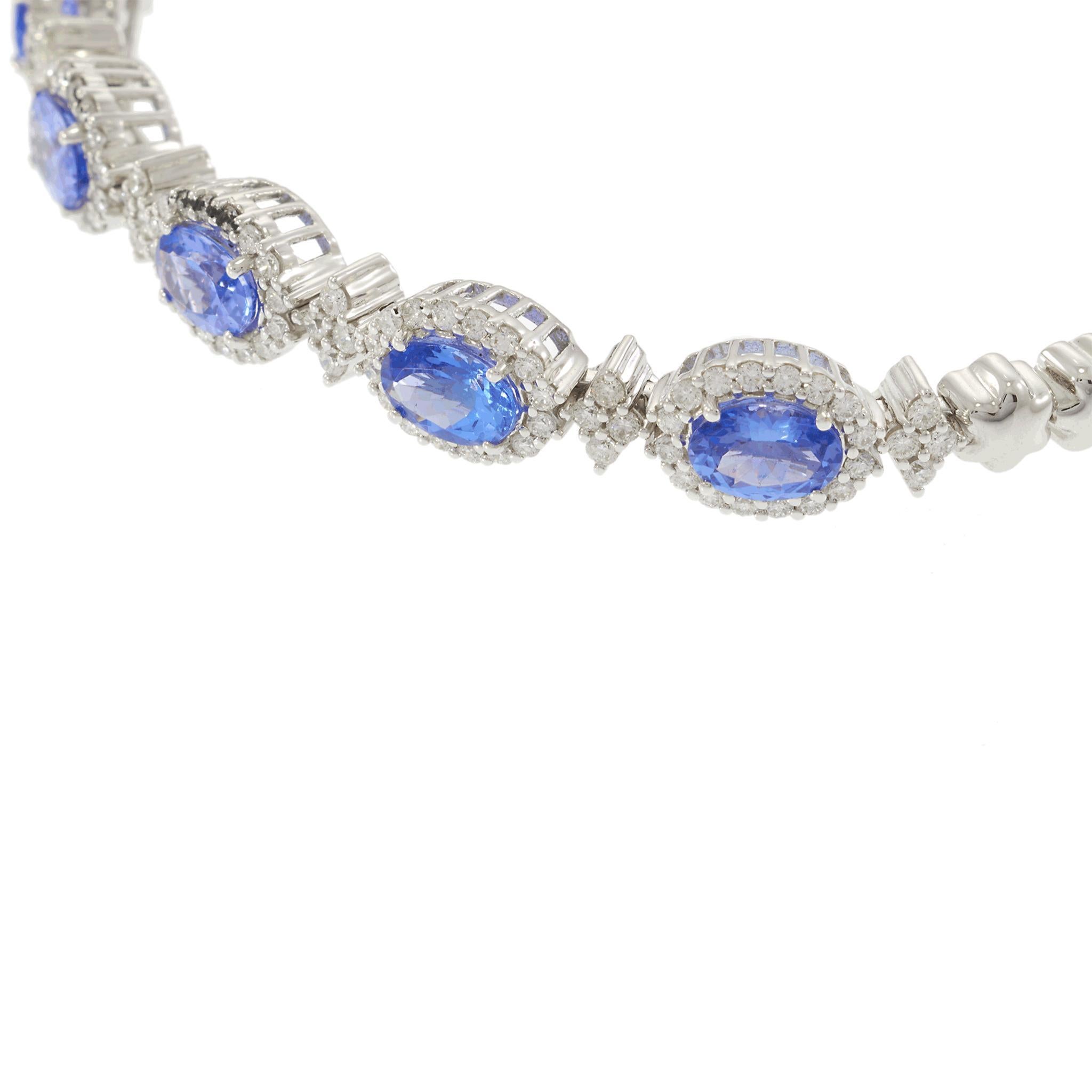Questo bracciale bangle in oro bianco 18 carati, che rappresenta una vera e propria dichiarazione di raffinatezza, presenta tanzaniti ovali blu per un totale di 3,82 carati, accentate da 1,26 carati di diamanti tondi brillanti. Ogni vibrante