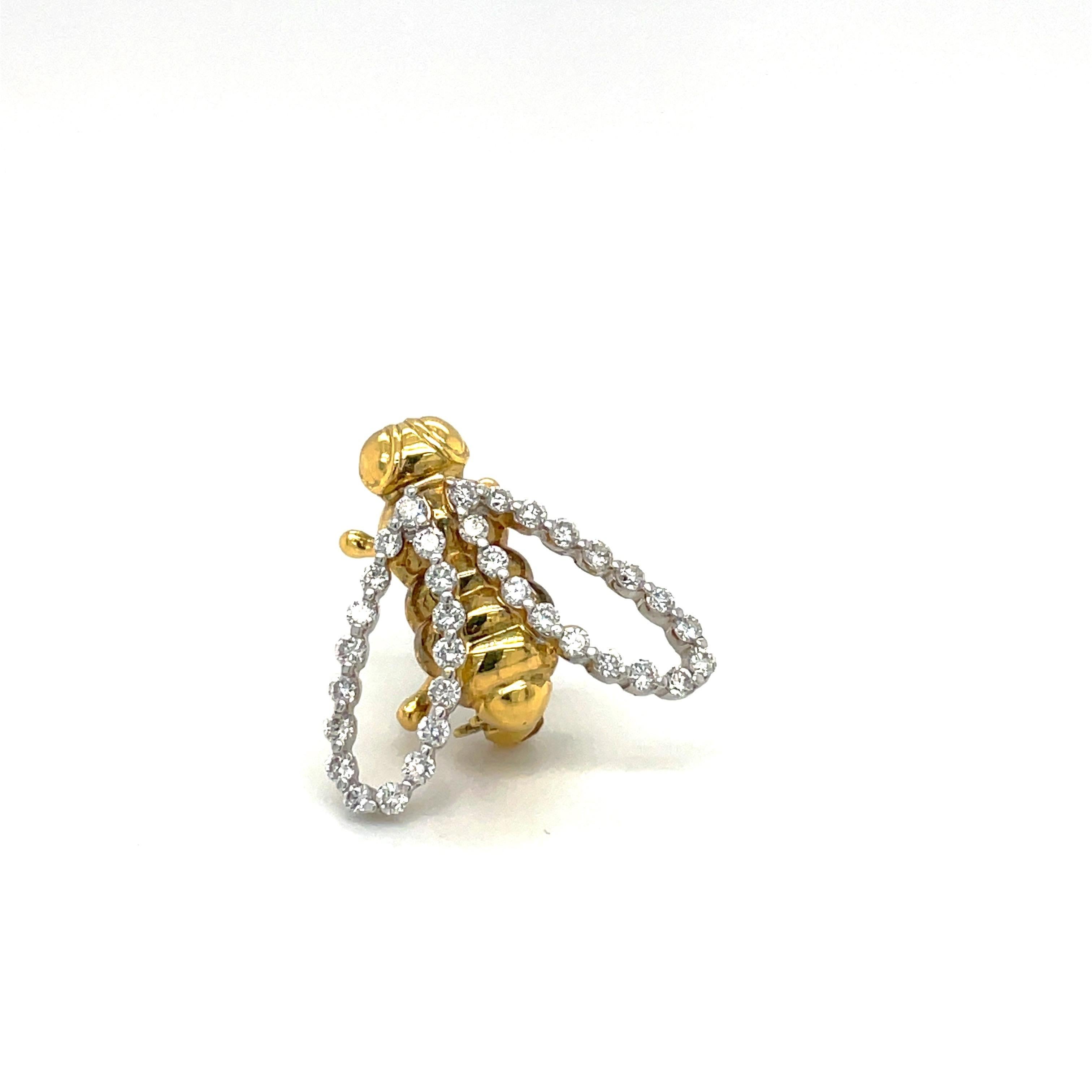 A lovely designed 18 karat yellow and white gold bee brooch. The bee is crafted in a high polished yellow gold. The  white gold wings are set with round brilliant diamonds. The setting is a 2 prong setting ,giving a seamless look. The bee measures