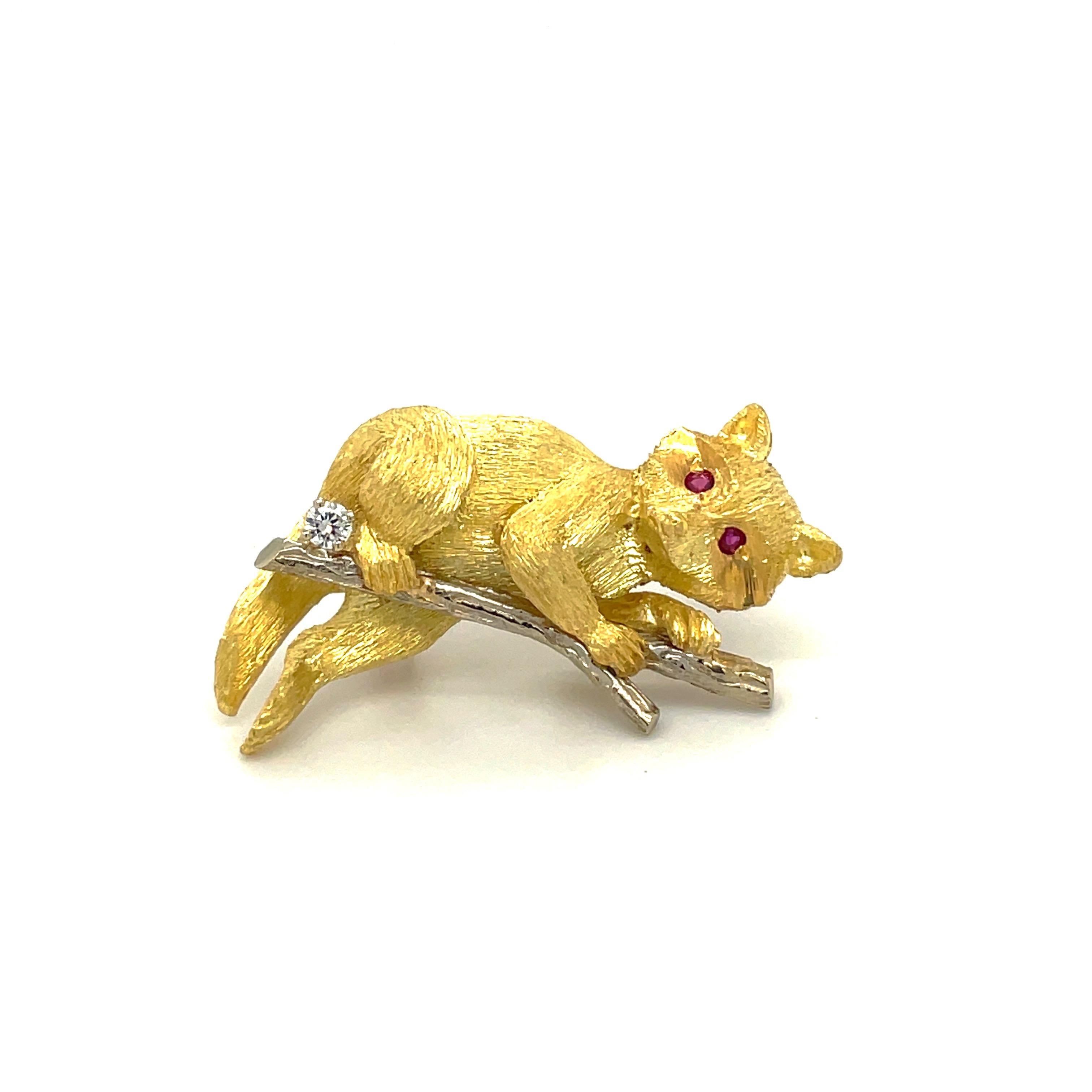 This charming 18KT gold raccoon brooch is brought to life with a variety of textures and precious stone accents. 