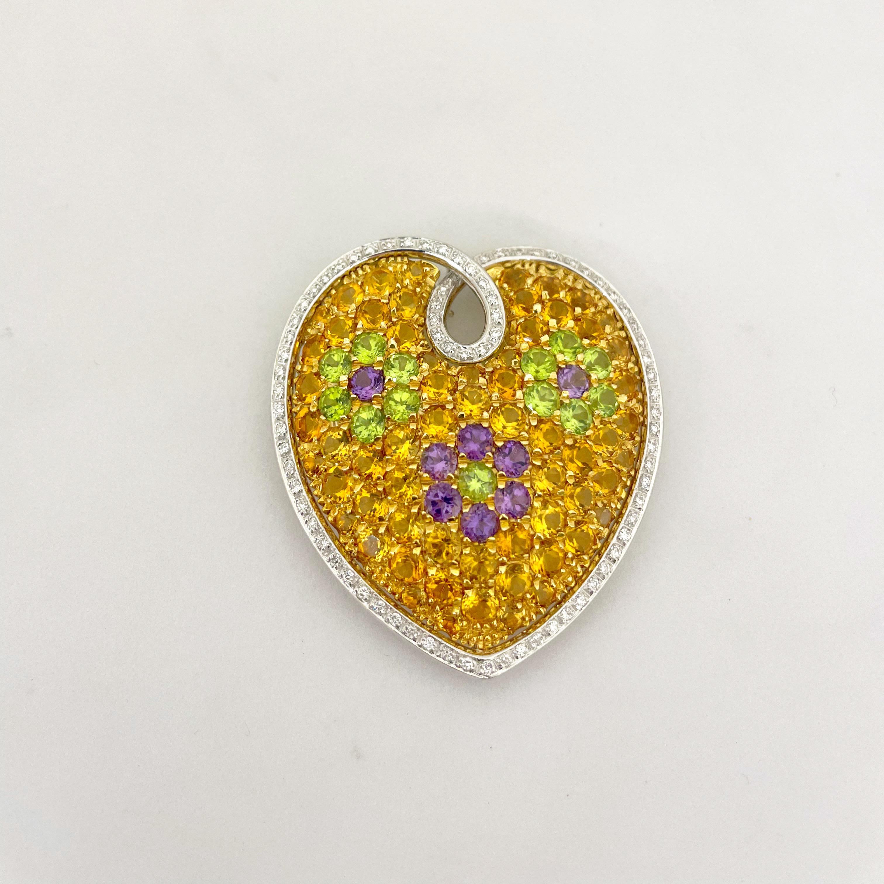 This lovely puffed heart diamond brooch by Cellini Jewelers NYC,  is made of green peridot, purple amethyst and orange citrine, a quite unique and beautiful combination of colors. The stones are set in 18kt yellow gold in a flower pattern and are