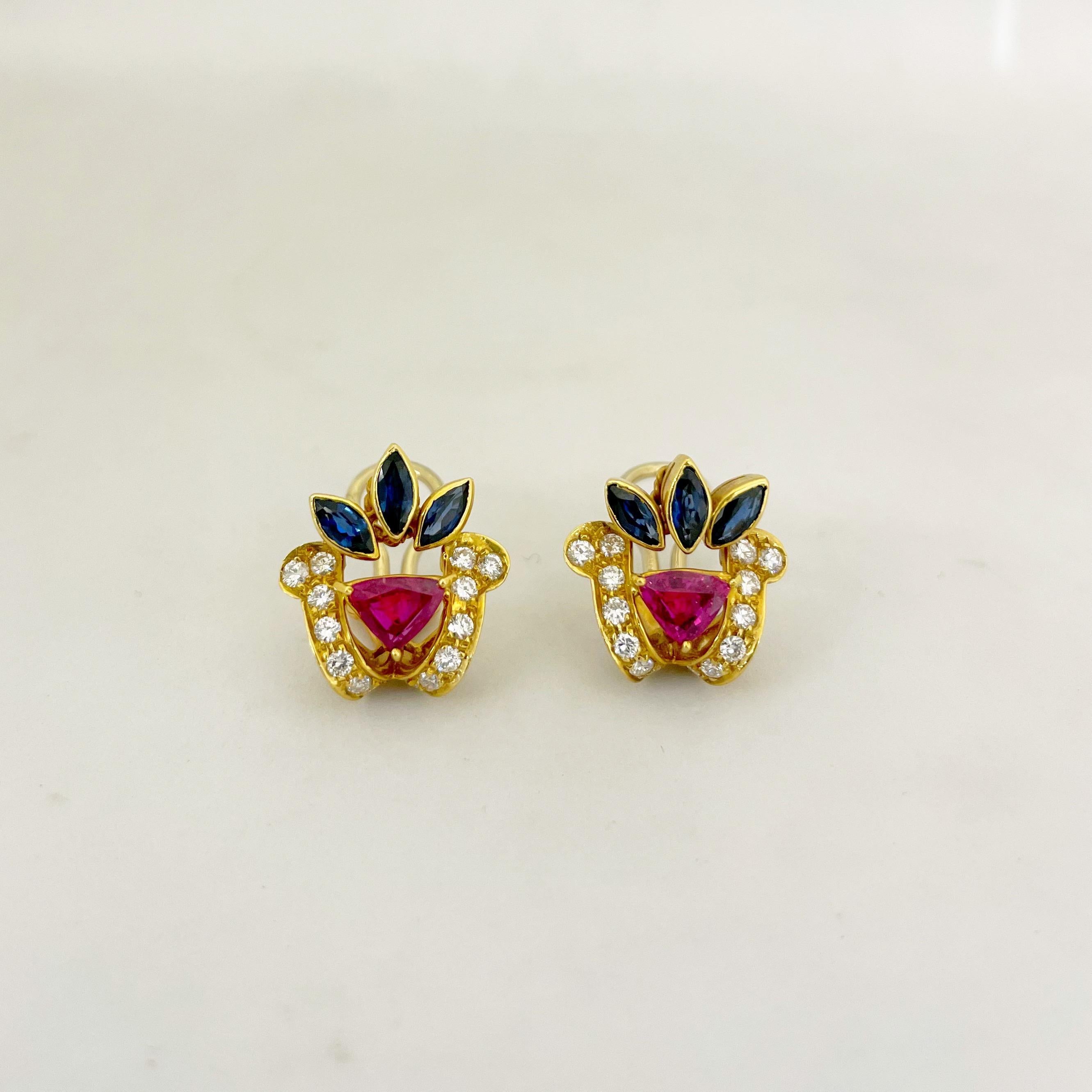 18 karat yellow gold earrings beautifully designed with marquis blue sapphires, trillion cut rubies and round brilliant diamonds. These earrings measure 7/8