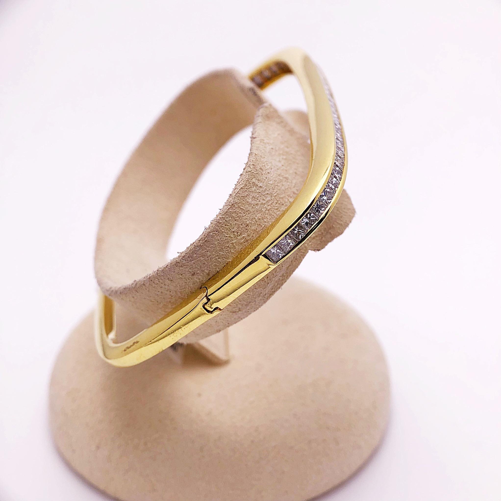 Featuring a modern 18 Kt Yellow Gold square bangle bracelet, this bracelet has been invisibly set with 2.96 carats of princess cut diamonds. The single row of diamonds create a beautiful sparkle across the wrist. The inside diameter is 2.25