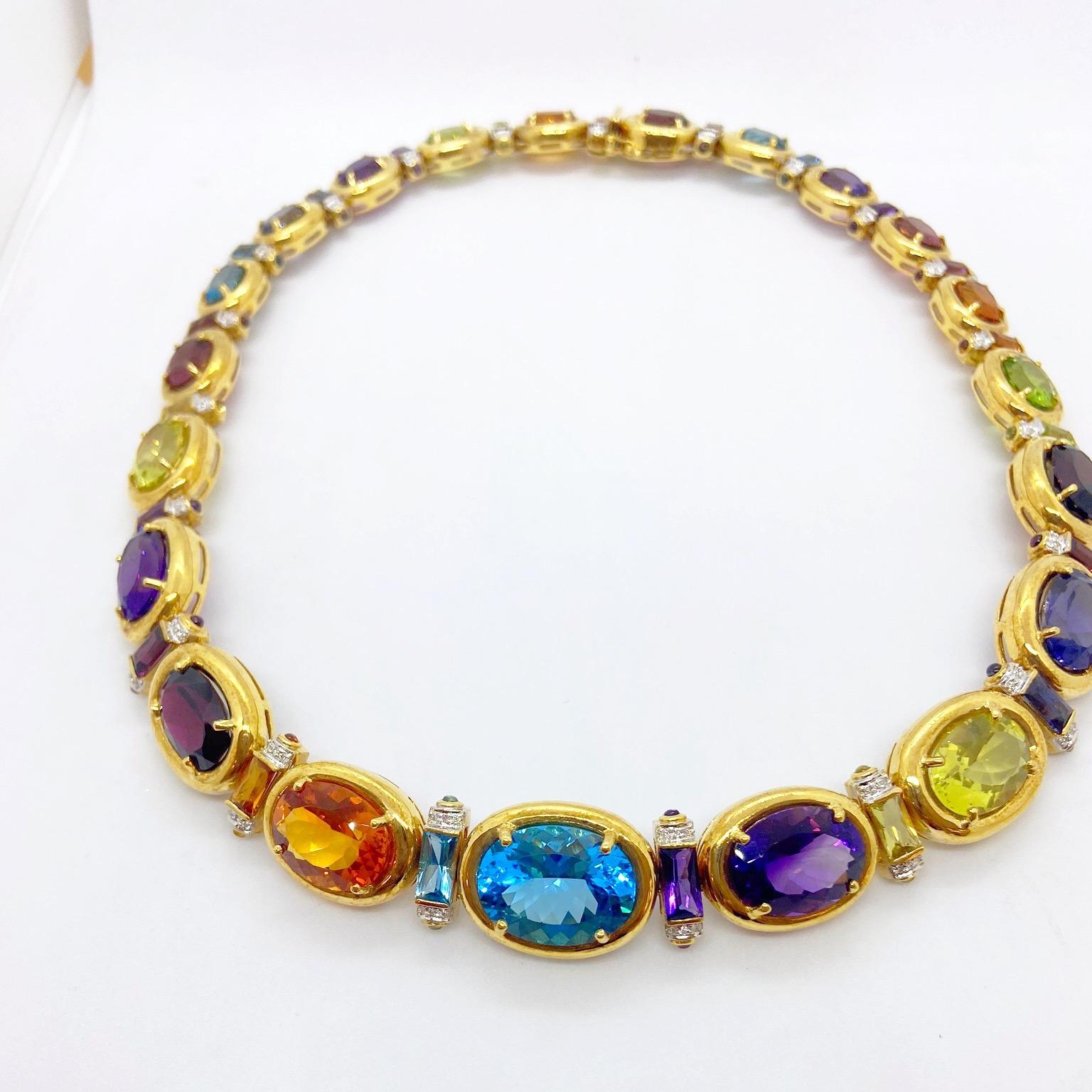 Brighten your day with this amazing Semi Precious colorful necklace.
The necklace is designed with 21 ovals in Blue Topaz, Citrine, Garnet, Amethyst, Lemon Quartz, Peridot ,Pink Tourmaline and Iolite. Each stone is set in an 18 karat yellow gold