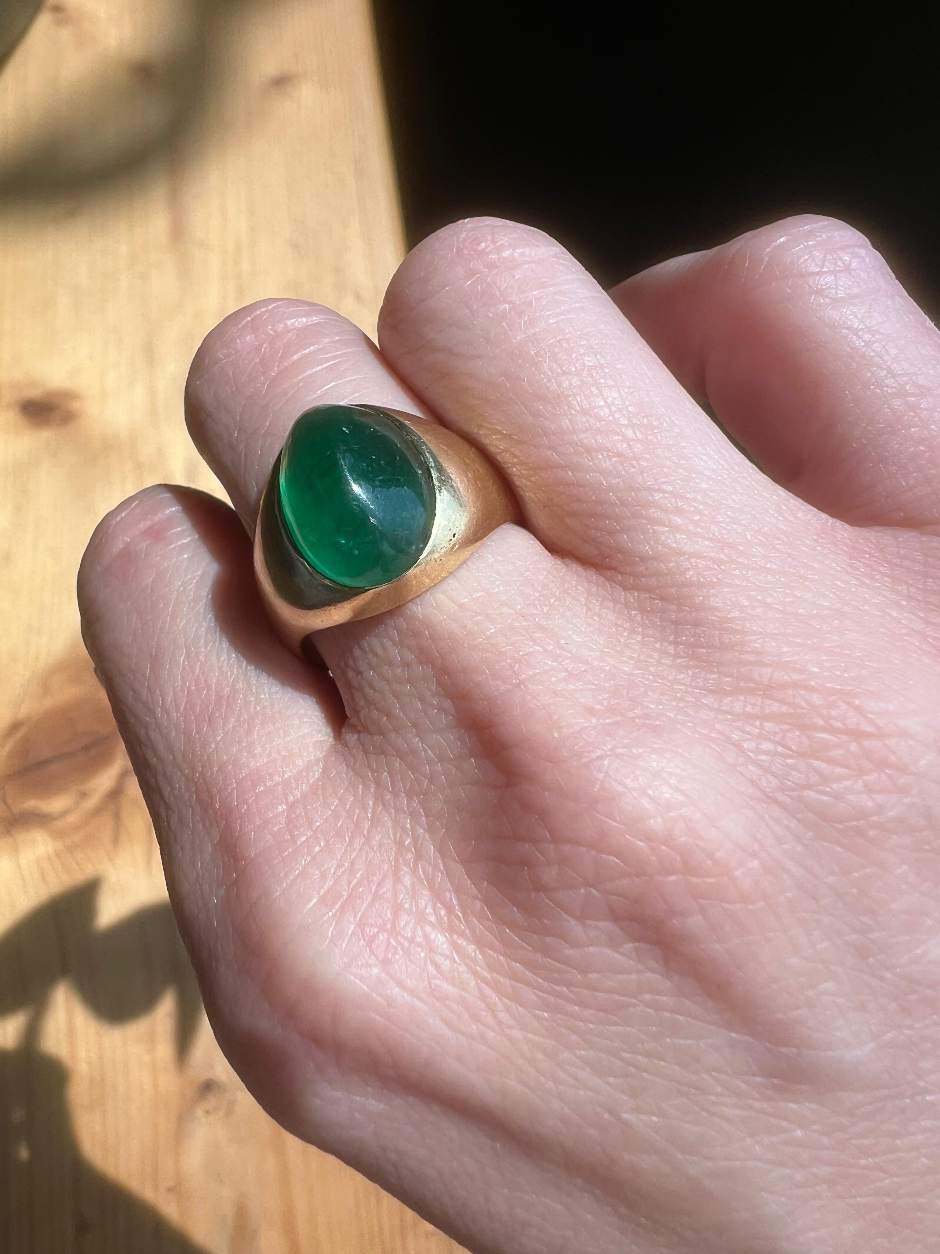 This 18kt. yellow gold emerald dome ring features a magnificent cabochon-cut emerald as its centrepiece, set in a smooth, polished yellow gold band. 

Made in Circa 1970s. 
Hallmarked with 18kt gold mark. 

The ring design is minimal yet powerful,