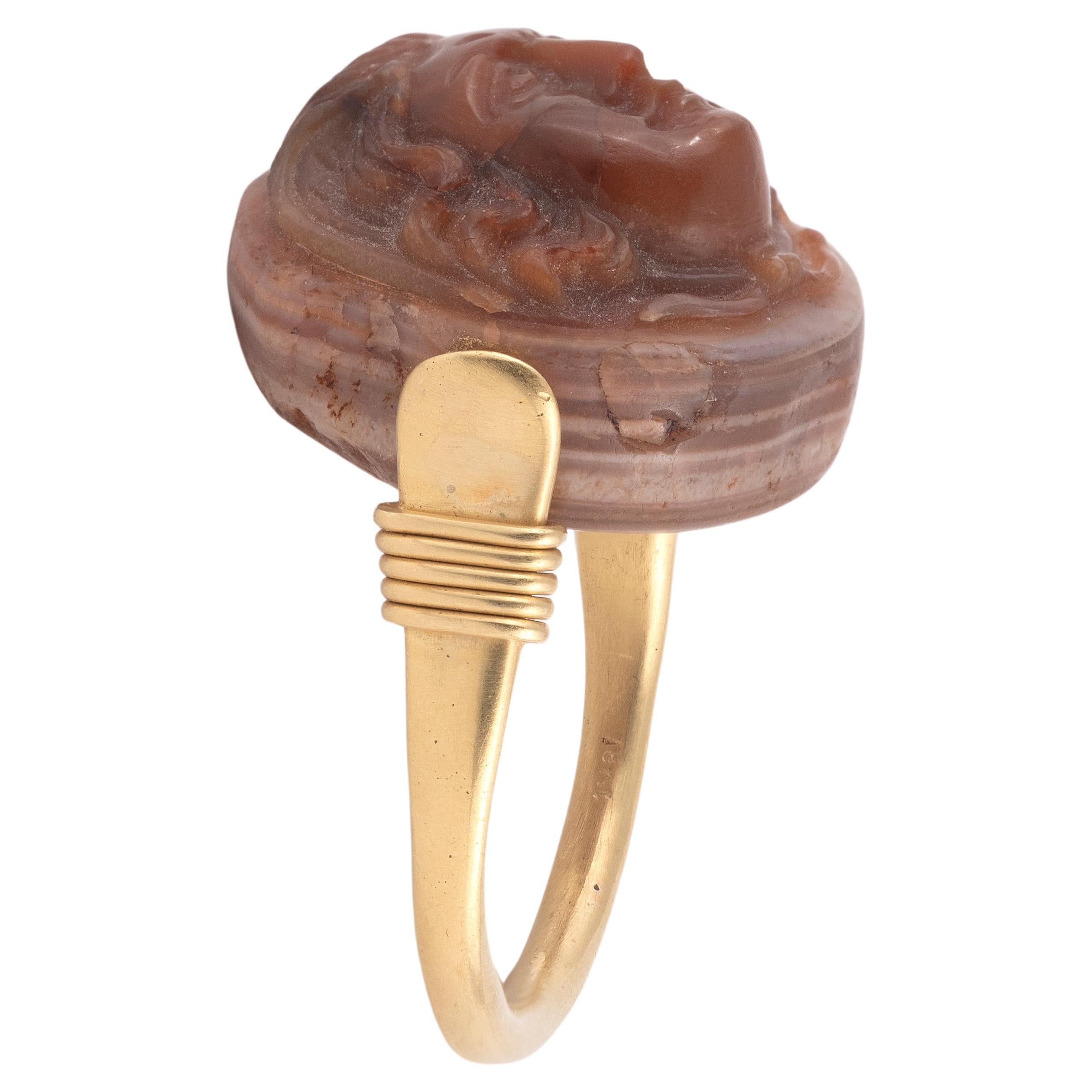 Ring set in 18kt yellow gold and an agate cameo depincting the front face of medusa, with a swivel circular bezel.

Dimensions of the cameo: 22mm
Finger size: 8 1/2
Gross weight: 17.32g.