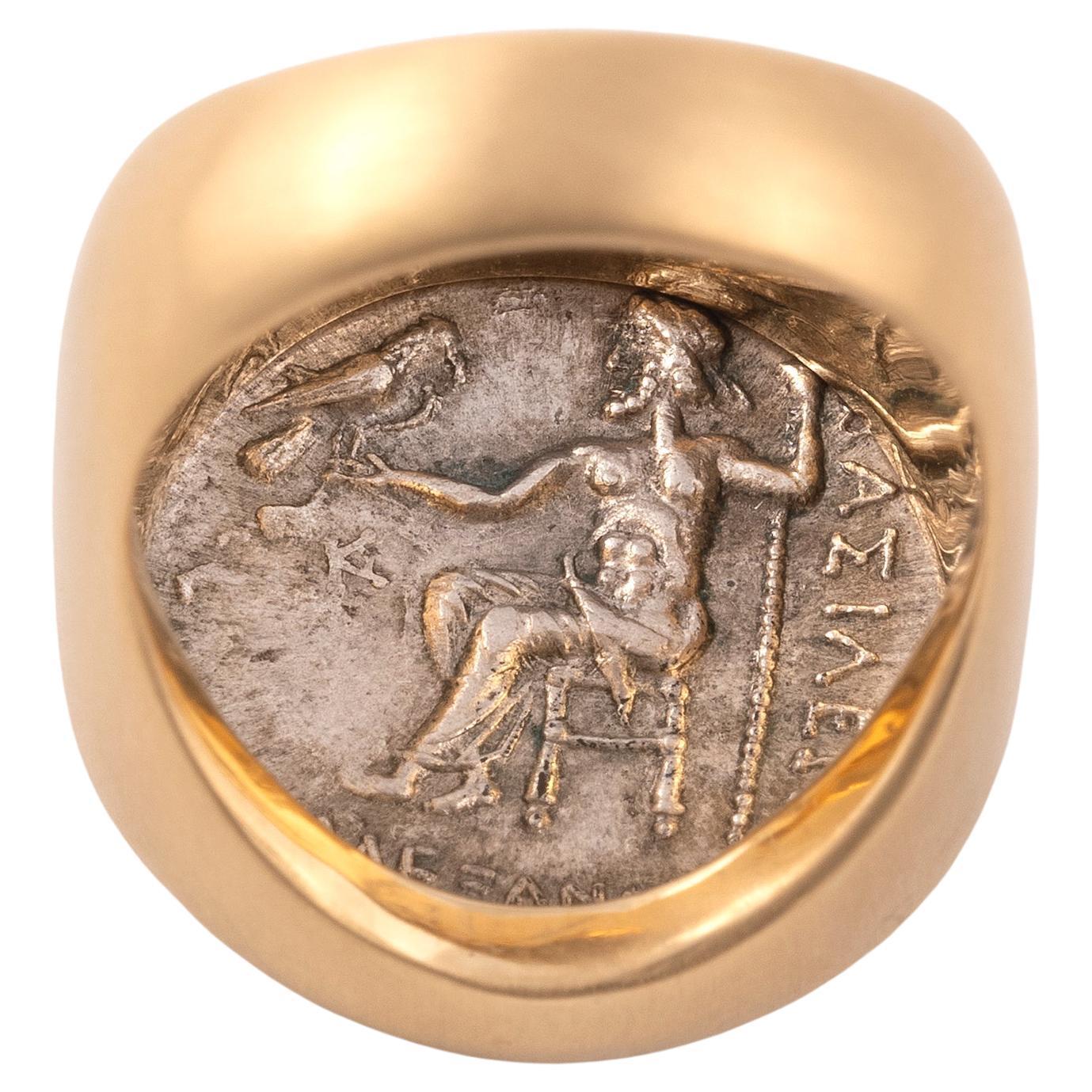 Alexander III the great silver dracm, circa 336-323 BC Head of Herakles; the strongest of all mortals, wearing lionskin headdress/ rev. God Zeus seated, holding sceptre and eagle.
18kt yellow gold Ring
Weight: 18.22gr
Size: 8 1/4
