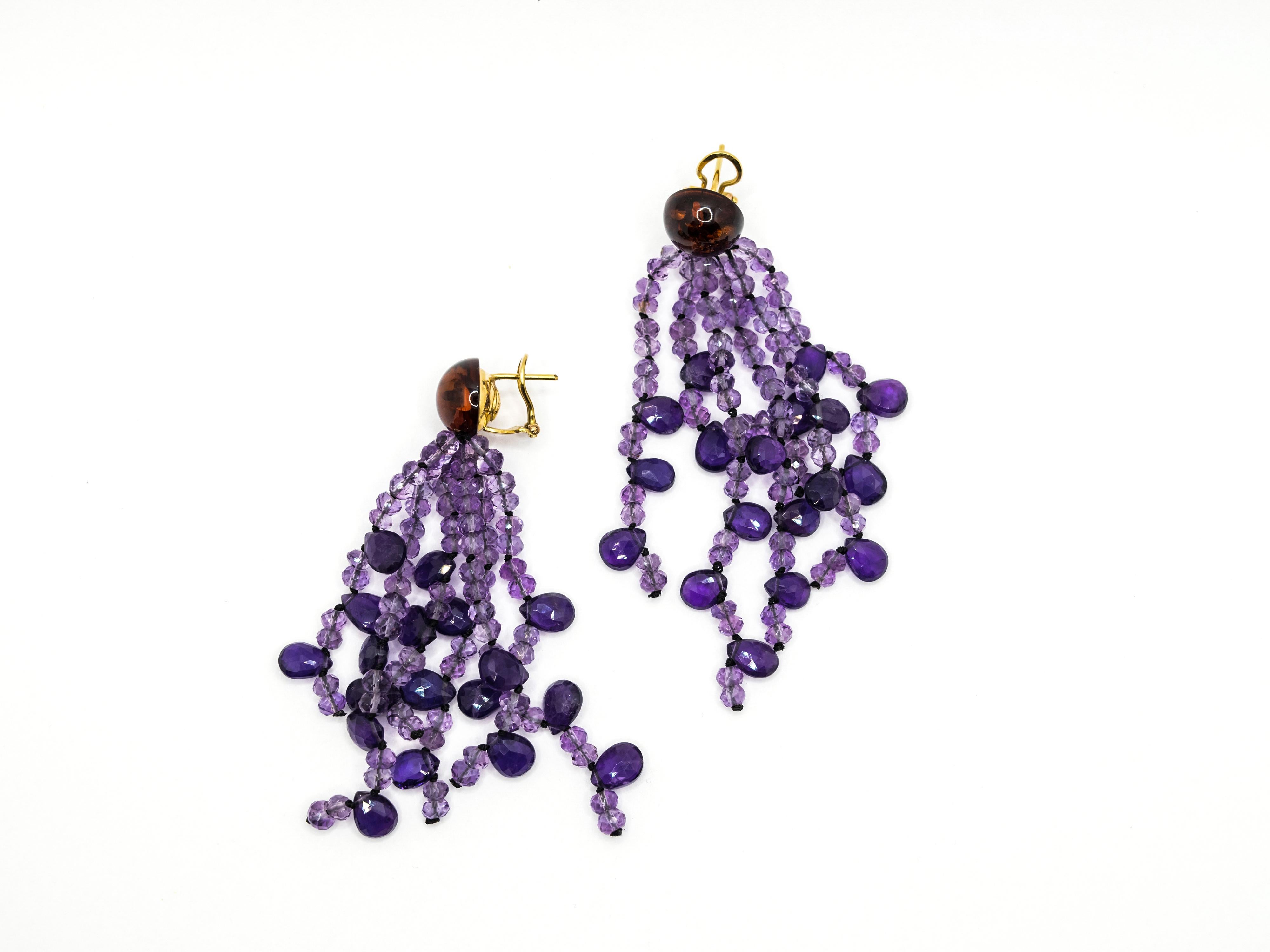These elegant earrings has a top side in Amber and 18 Kt yellow gold clip closure.
The dangling side is made of six two tone Amethyst wire.
The stones has two different briolette cut, round for the light ones and drop for the dark ones.
These